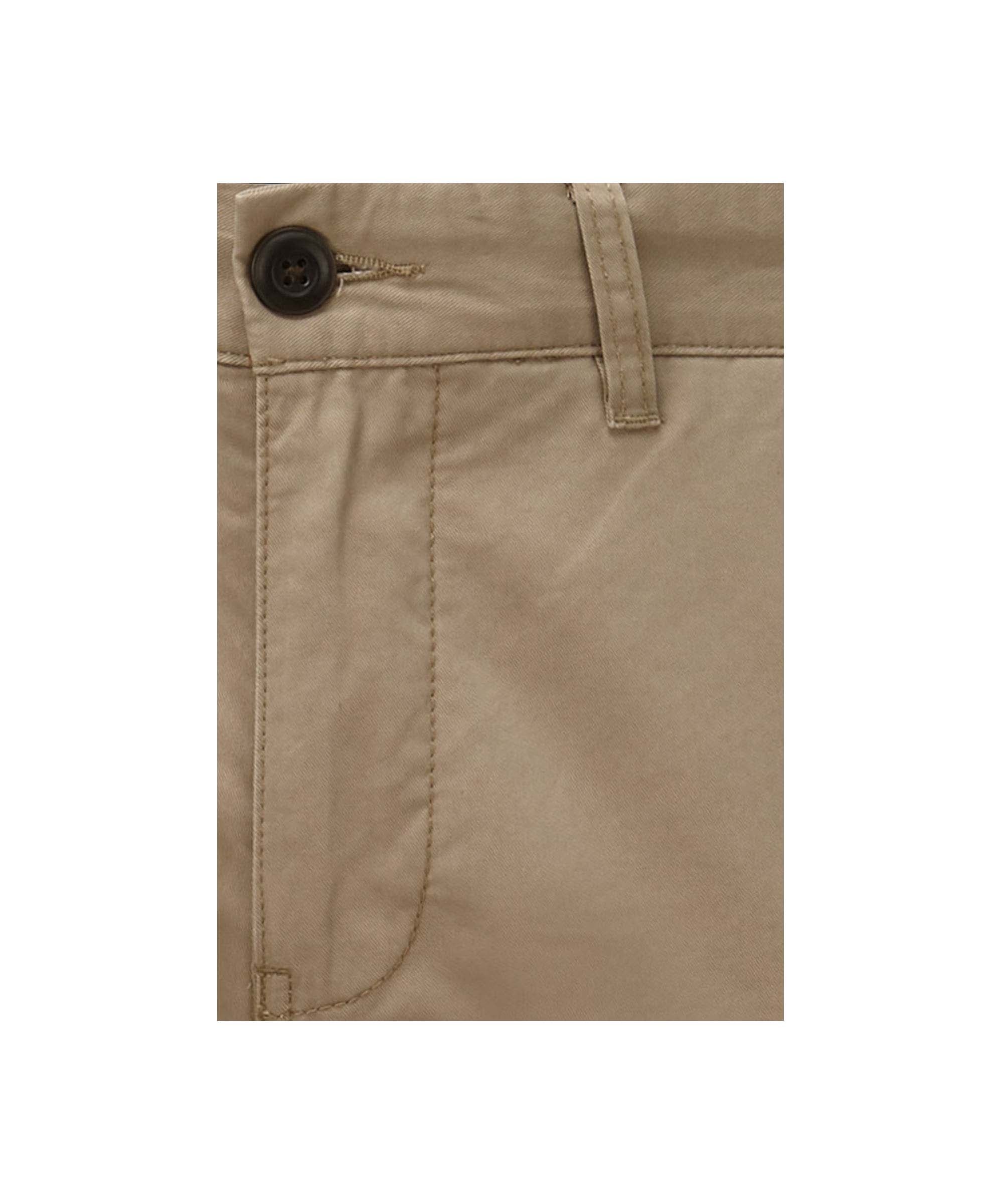 Close-up of beige trousers with a button on a white background