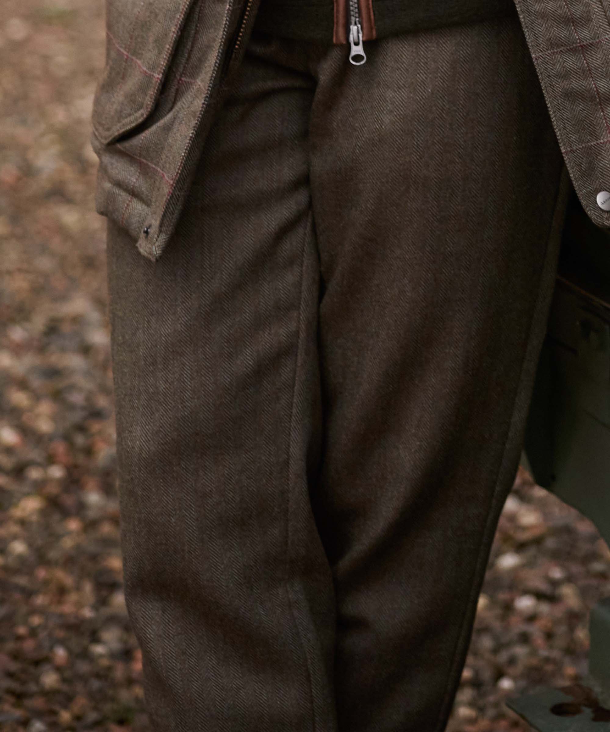 Close-up of the zip-fly detail on Schöffel Country's brown herringbone tweed trousers, worn with a matching jacket