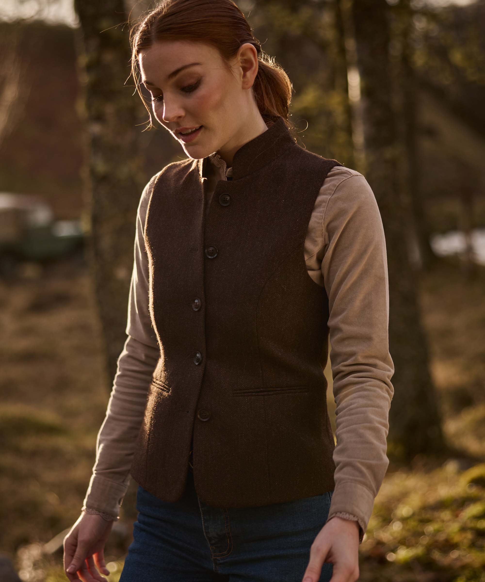 Woman wearing Schöffel Country's brown herringbone tweed gilet over a fawn corduroy shirt