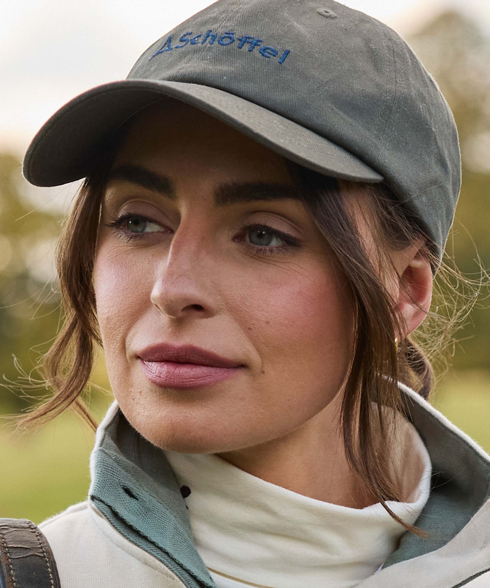 Woman wearing a cap with 'Schöffel' logo outdoors