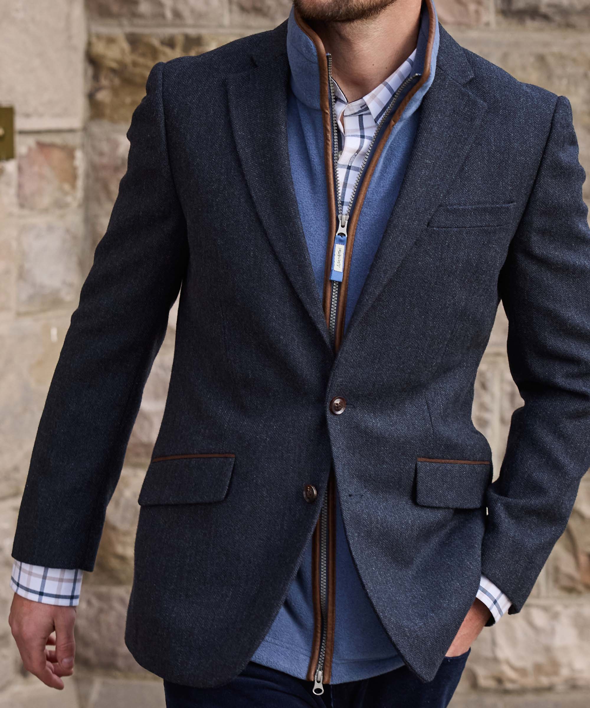 Man wearing Schöffel Country's navy herringbone tweed blazer with leather-trimmed zip gilet, close-up on chest