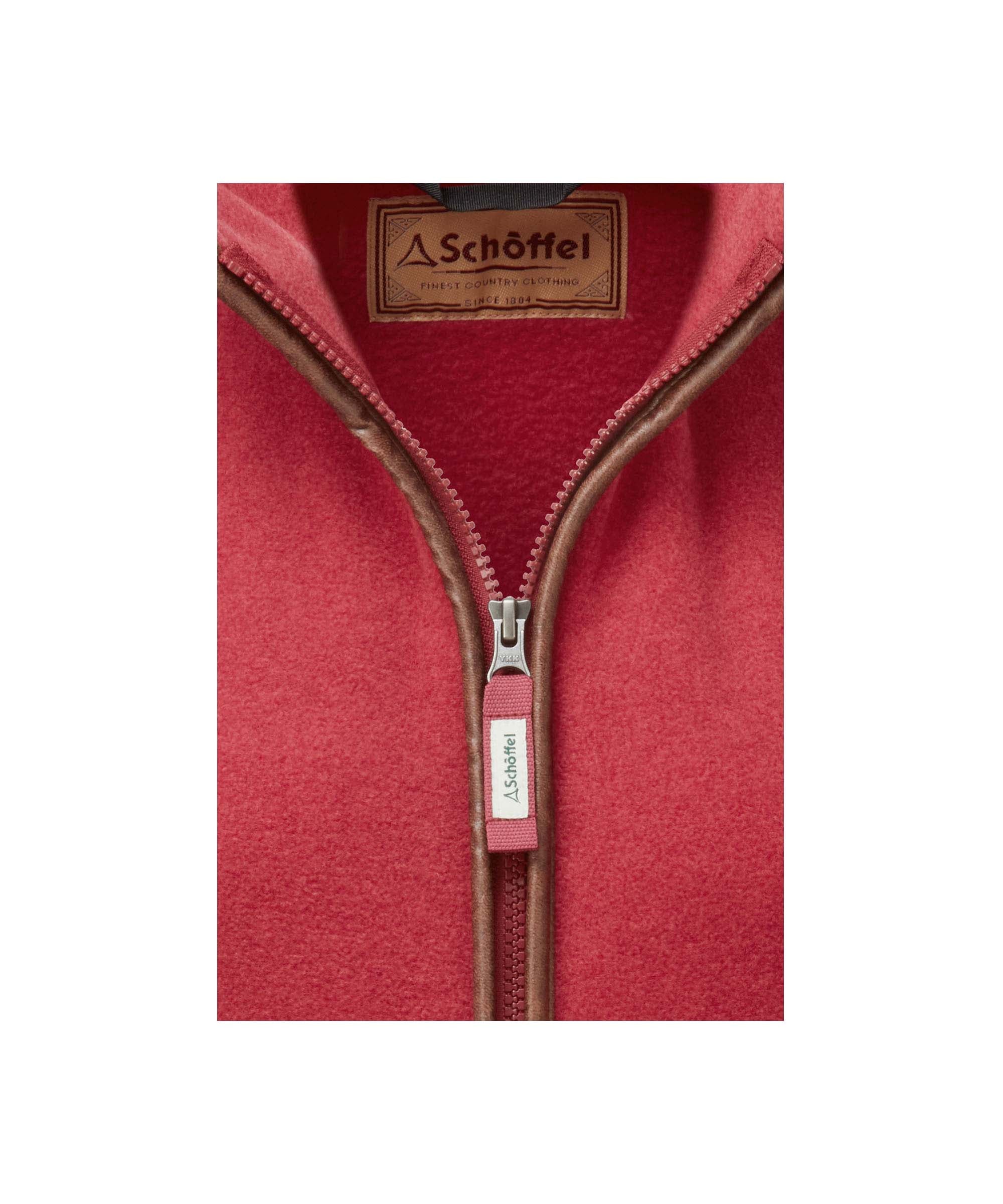 Schöffel Women's Fleece Gilet in Red close-up showing full-zip opening with leather trim and Schöffel heritage label detail