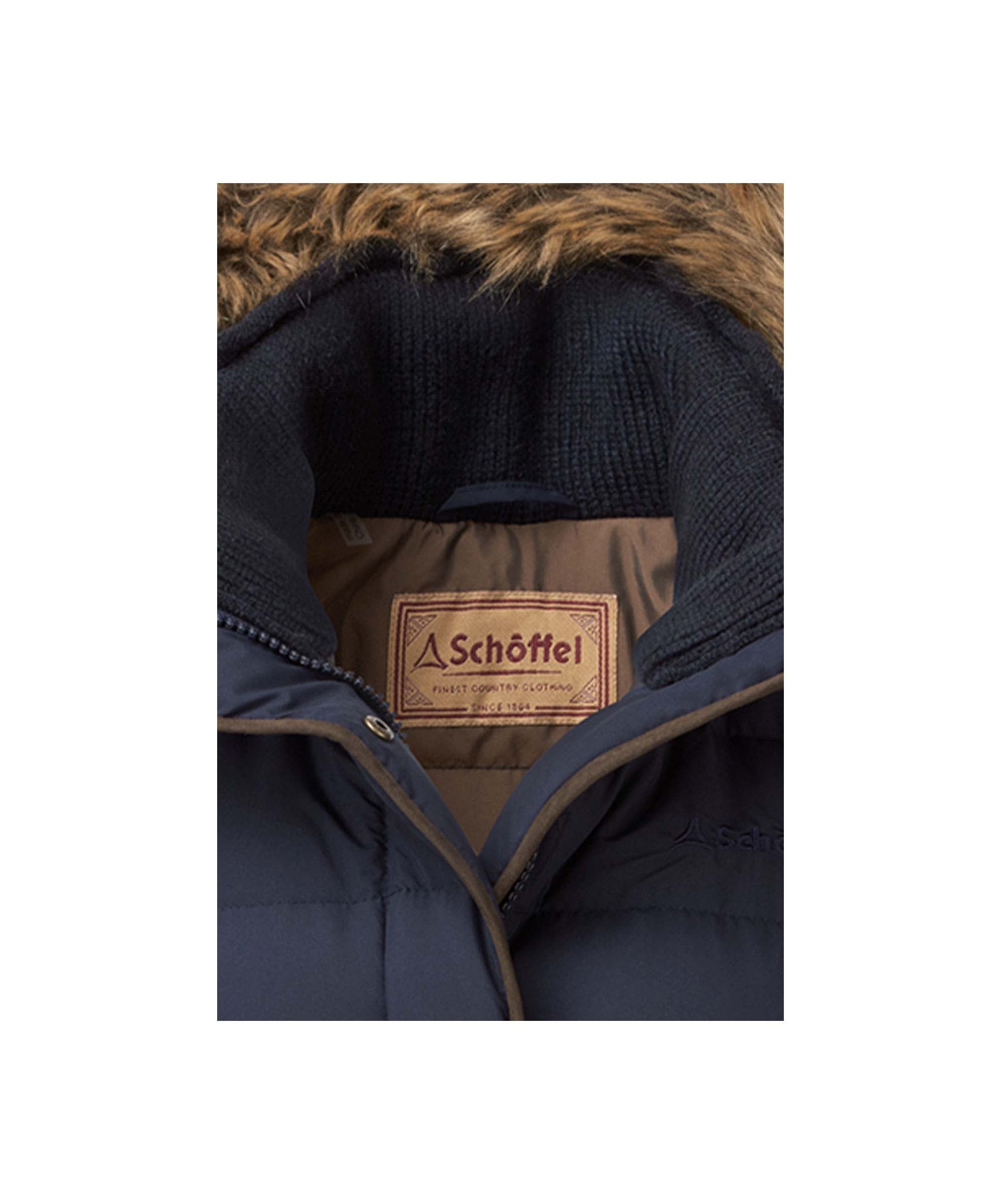 Schöffel Women's Down Jacket in Navy close-up showing fur-trim hood, knit inner collar and branded heritage label detail