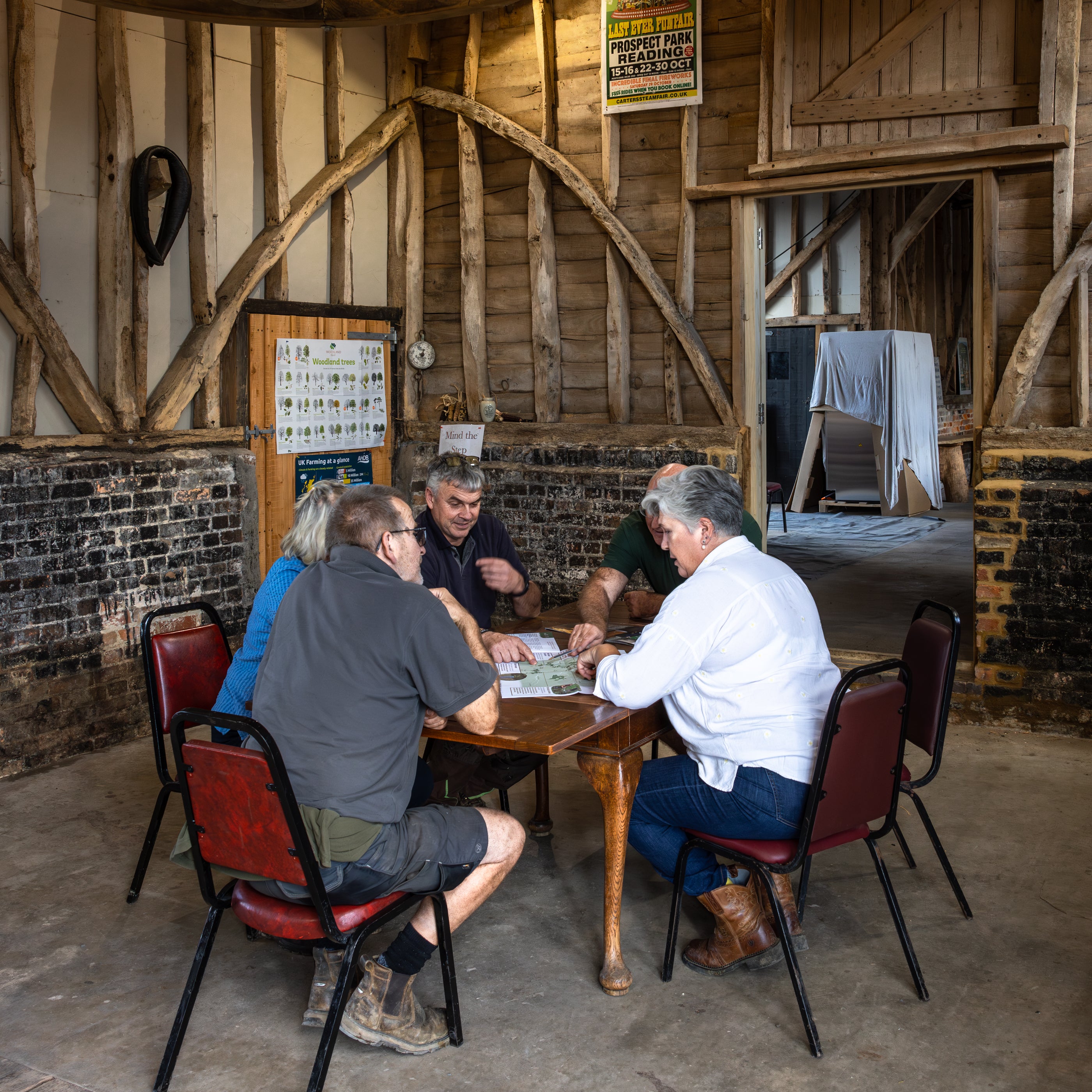 Group of people sitting around a table in a rustic wooden building.