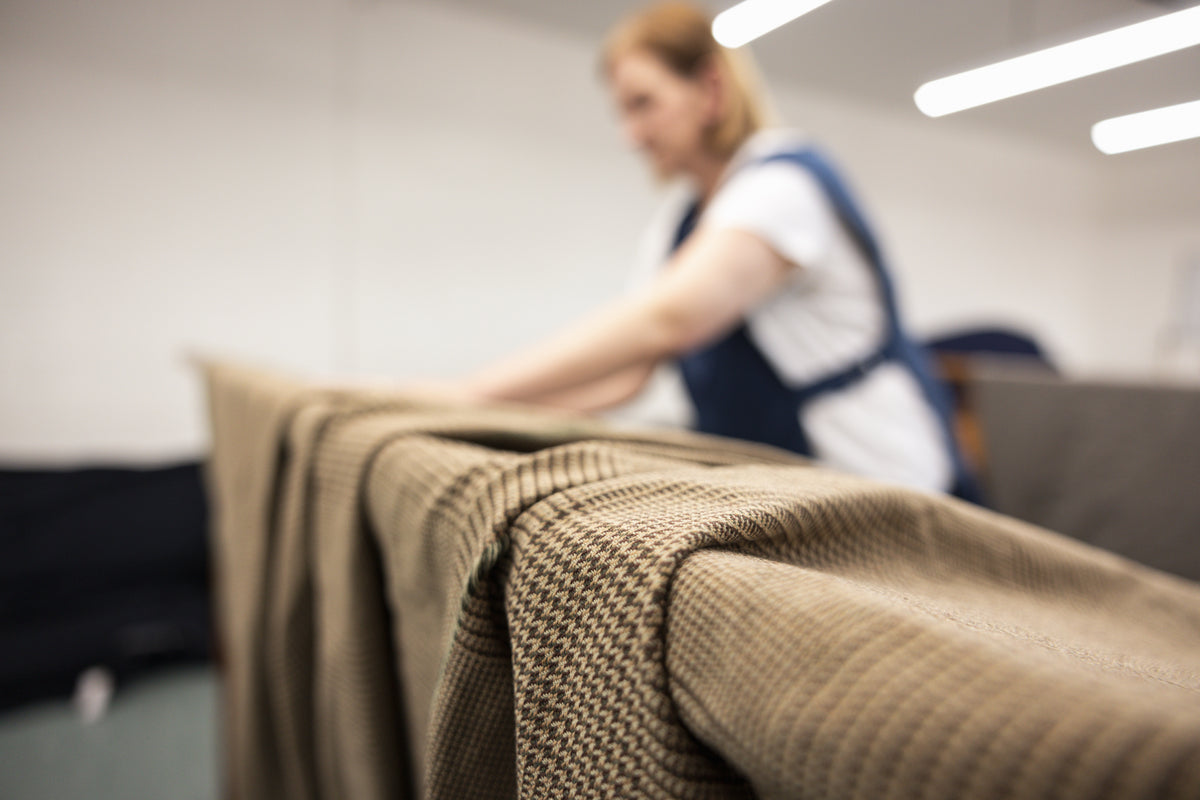 A close-up of tweed fabric draped in the foreground