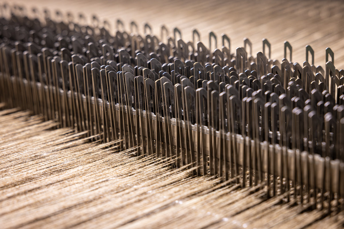 Close-up of a loom machine needle bed.