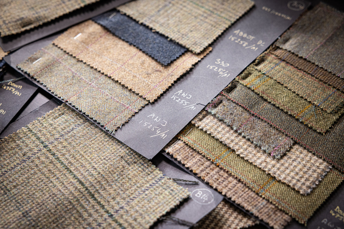 A close-up arrangement of fabric and tweed swatches on dark cards.
