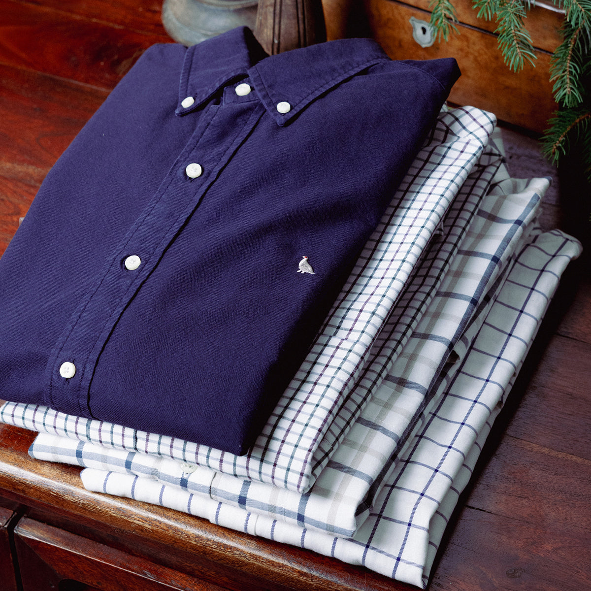 Folded navy and check shirts stacked as gifts under one hundred