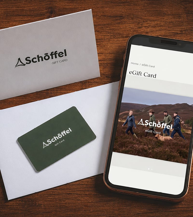 Schöffel gift card set shown on a wooden tabletop, including a branded card, a white envelope