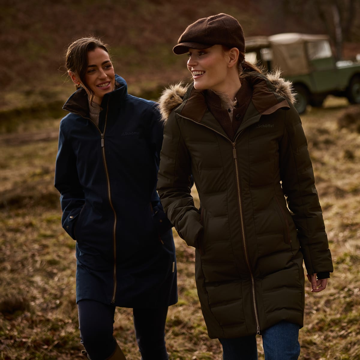 Two friends walk countryside trails in navy waterproof and fur-trimmed quilted coats