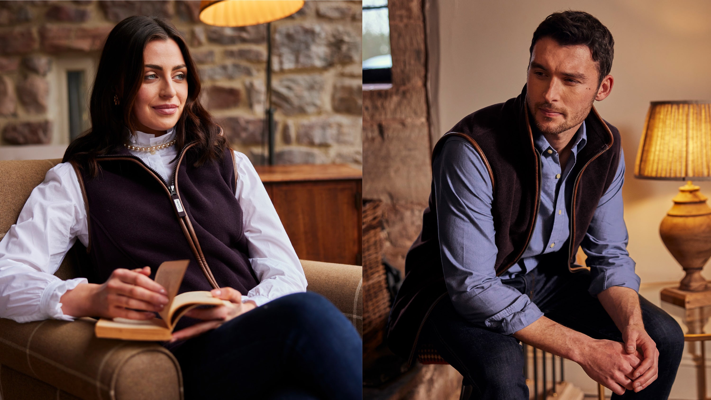 A man and a woman sitting in a cottage style house, she is wearing a white shirt, blue trousers and a dark purple gilet. He is wearing dark navy jeans, a light blue shirt and a dark purple gilet.