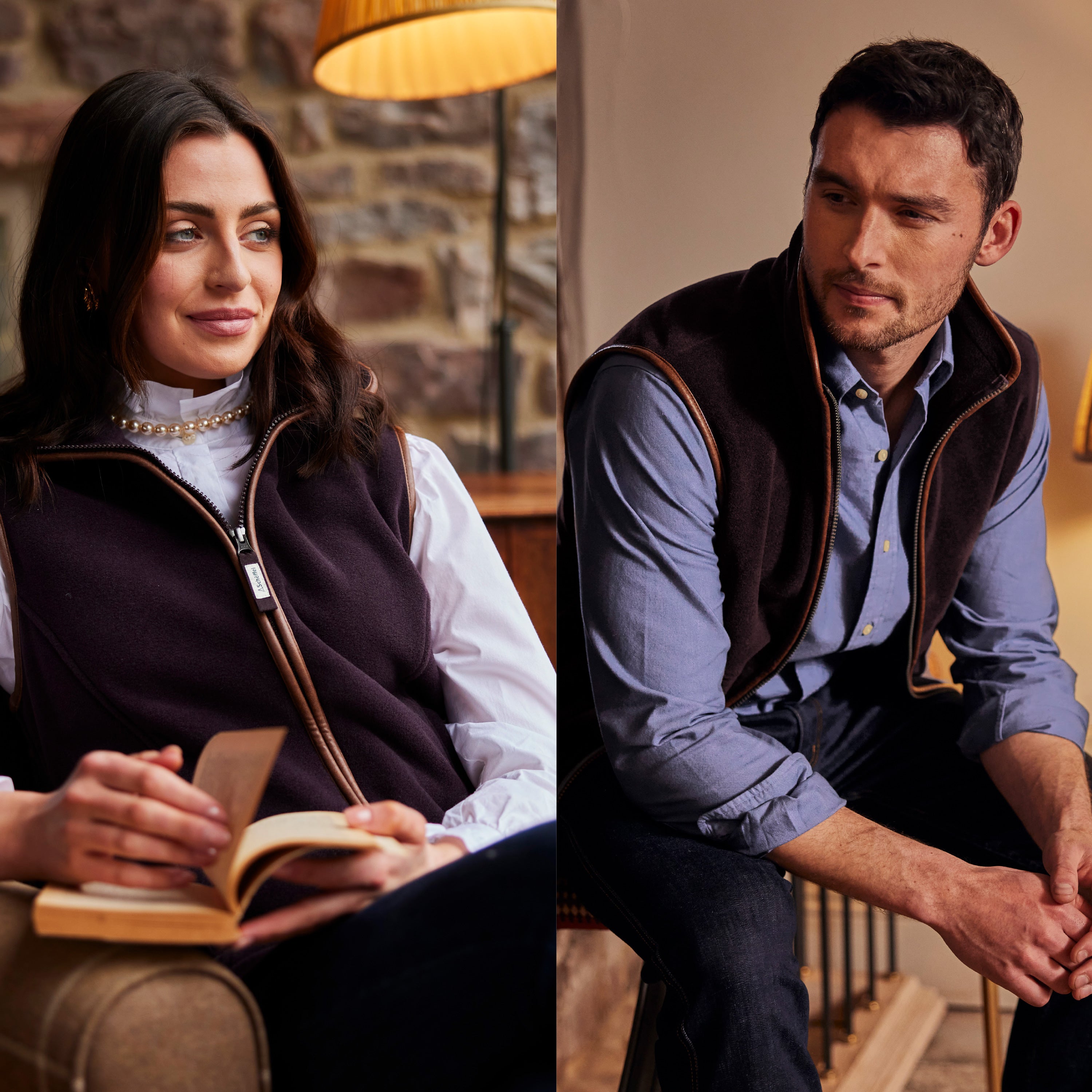 A man and a woman sitting in a cottage style house, she is wearing a white shirt, blue trousers and a dark purple gilet. He is wearing dark navy jeans, a light blue shirt and a dark purple gilet.