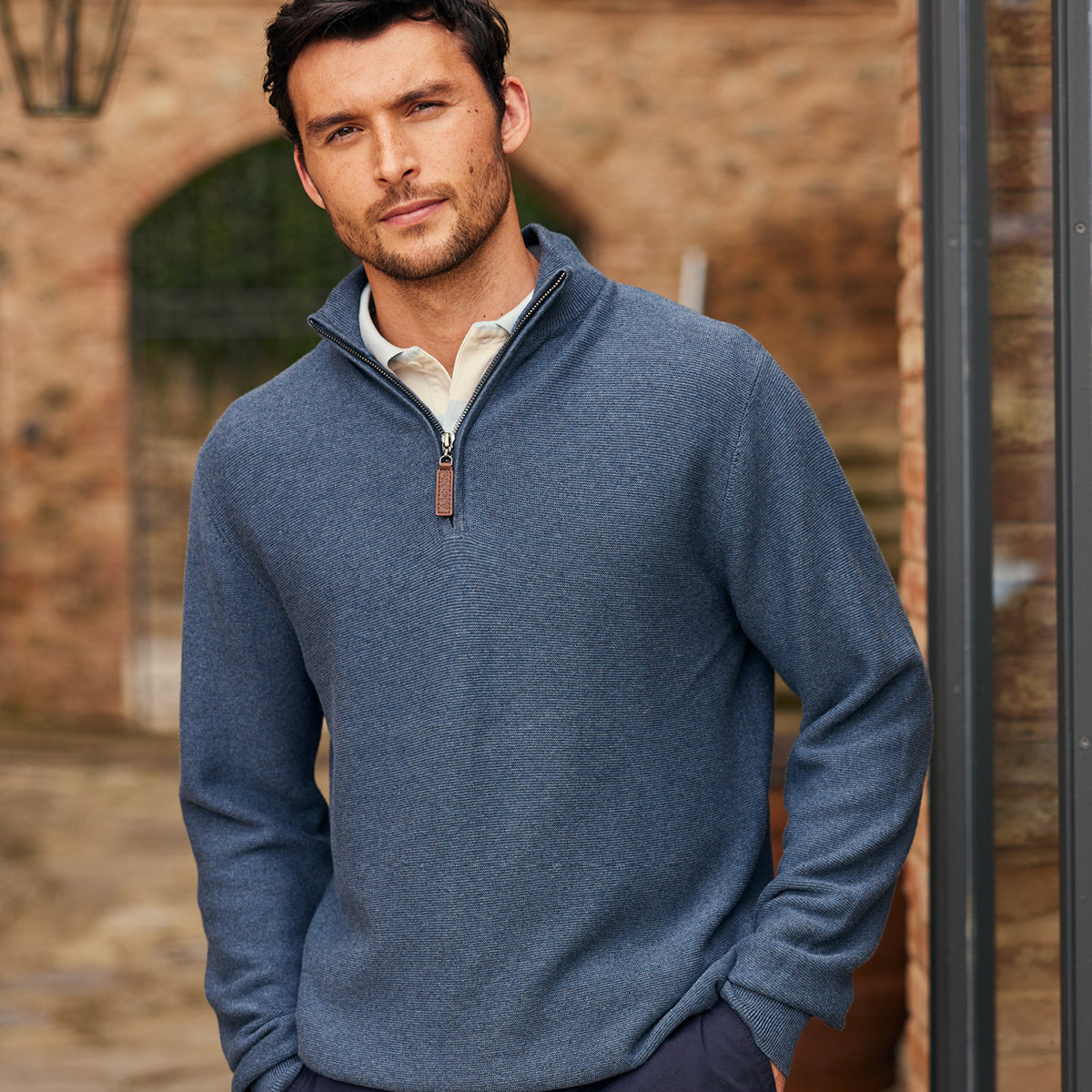 Man wearing a blue knit with a blurred background