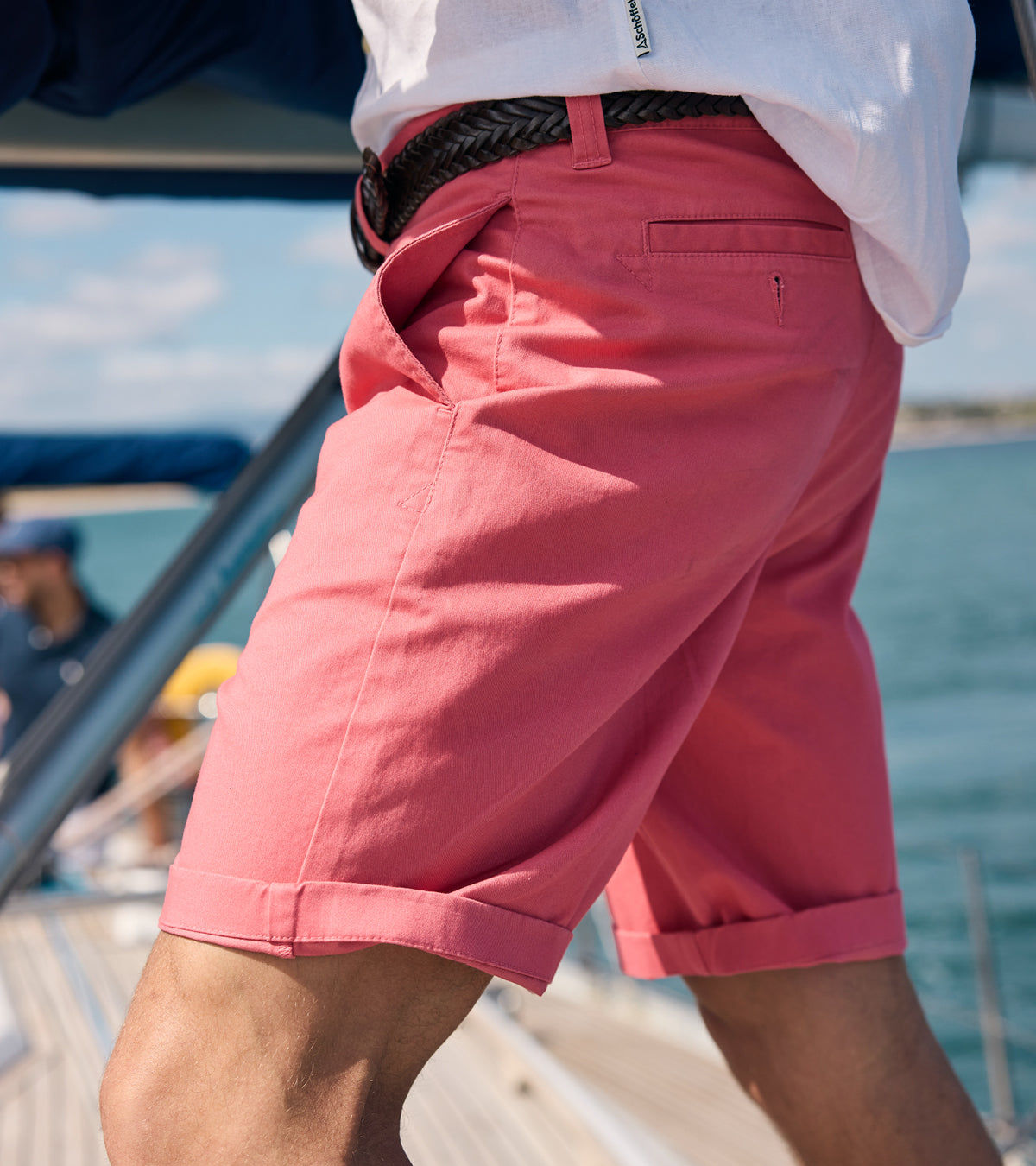 Person wearing pink shorts on a boat with water and sky in the background