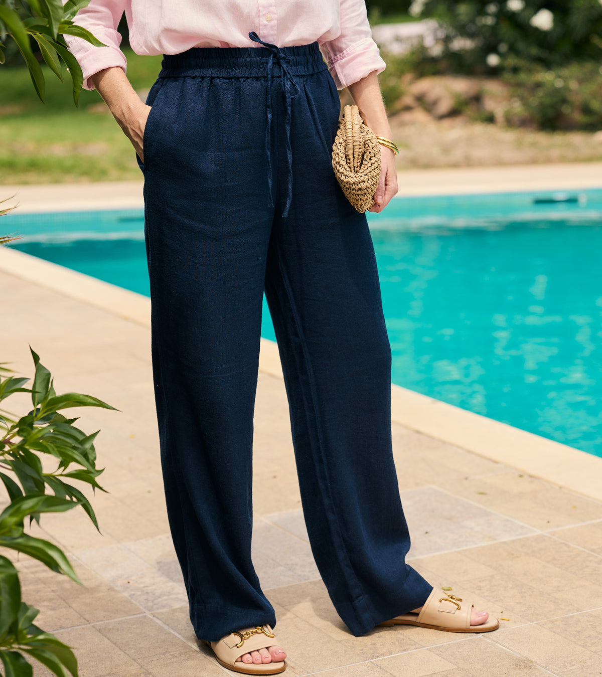 Person wearing navy pants by a poolside