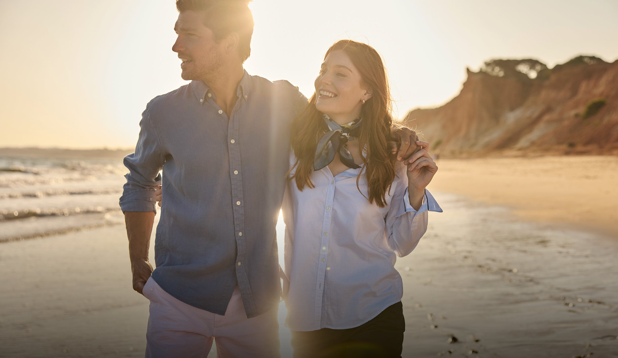 Couple walking on a beach at sunset