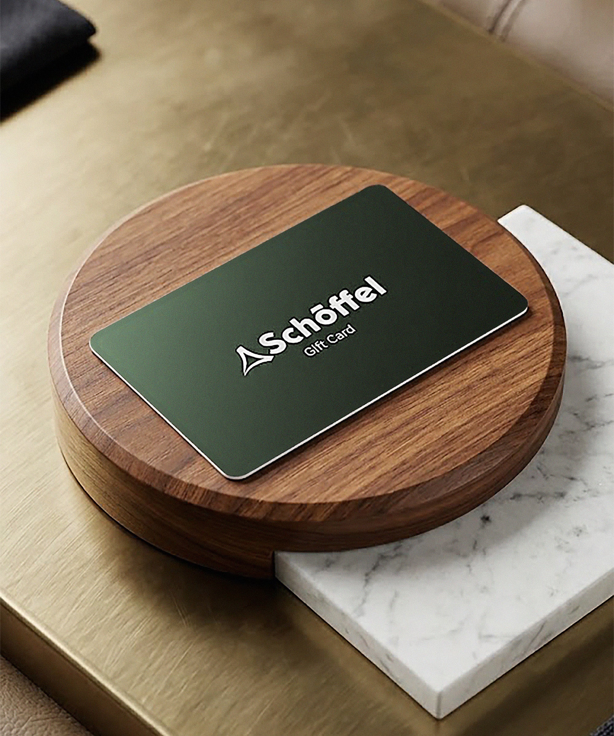 Schöffel gift card on a wooden coaster with marble surface