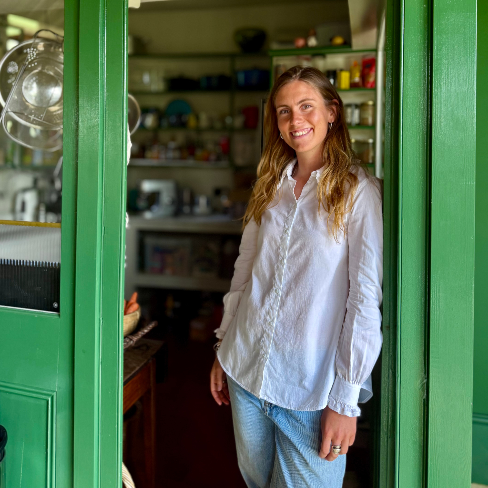 Woman standing in a kitchen with green doors