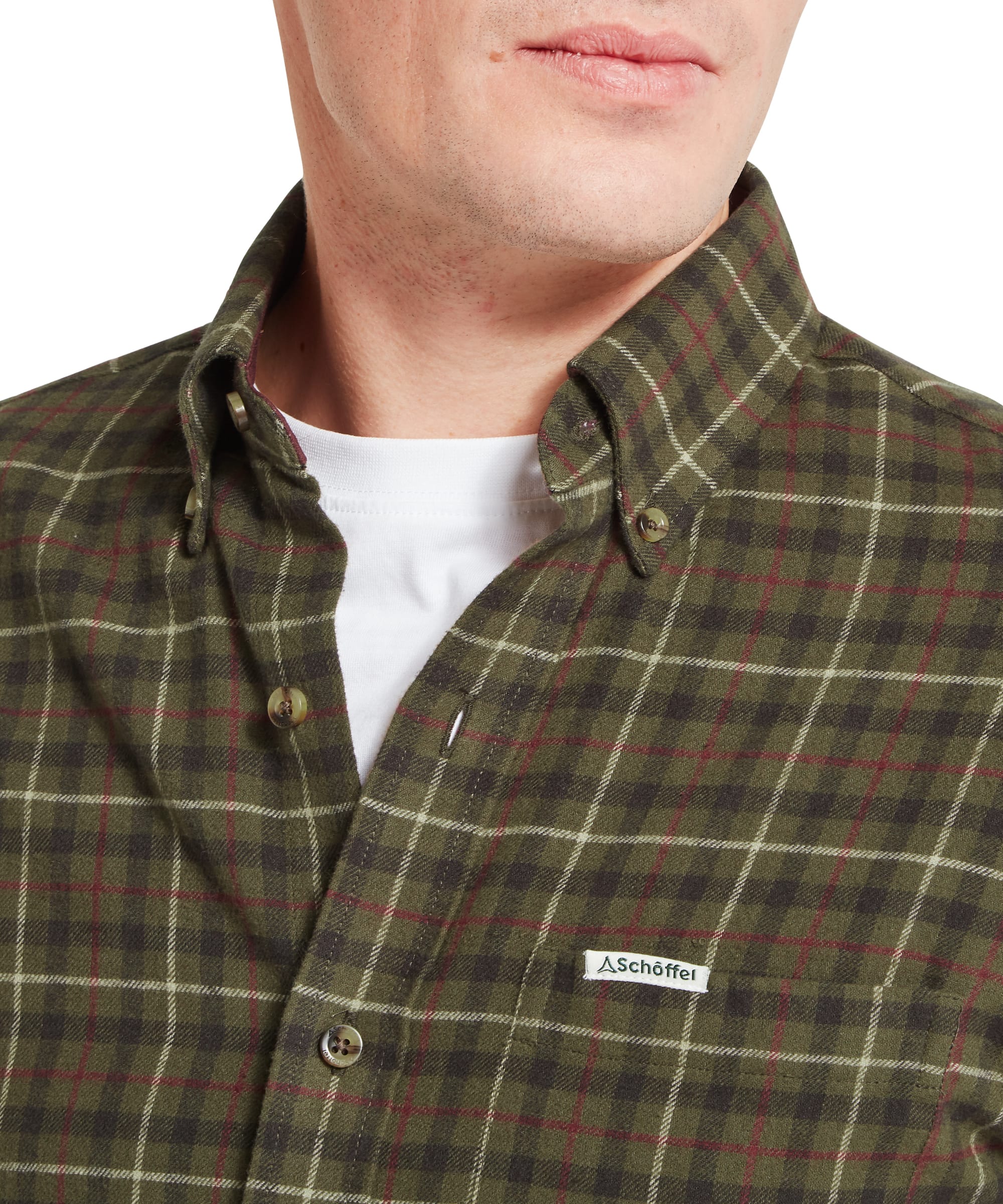 Schöffel Men's Akenham Shirt in Green - side profile view showing the relaxed fit, curved hem, and contrast burgundy wax cotton cuff, worn with blue jeans.