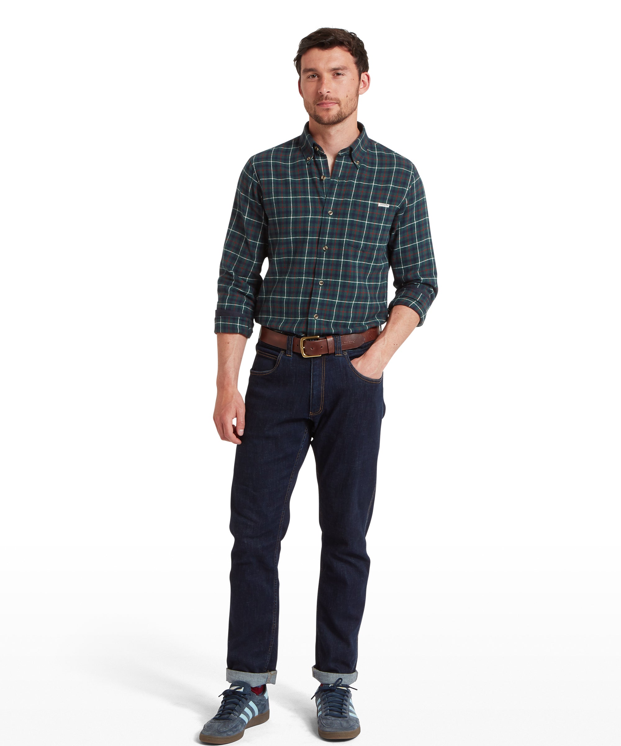 Man wearing a plaid shirt and dark jeans on a white background