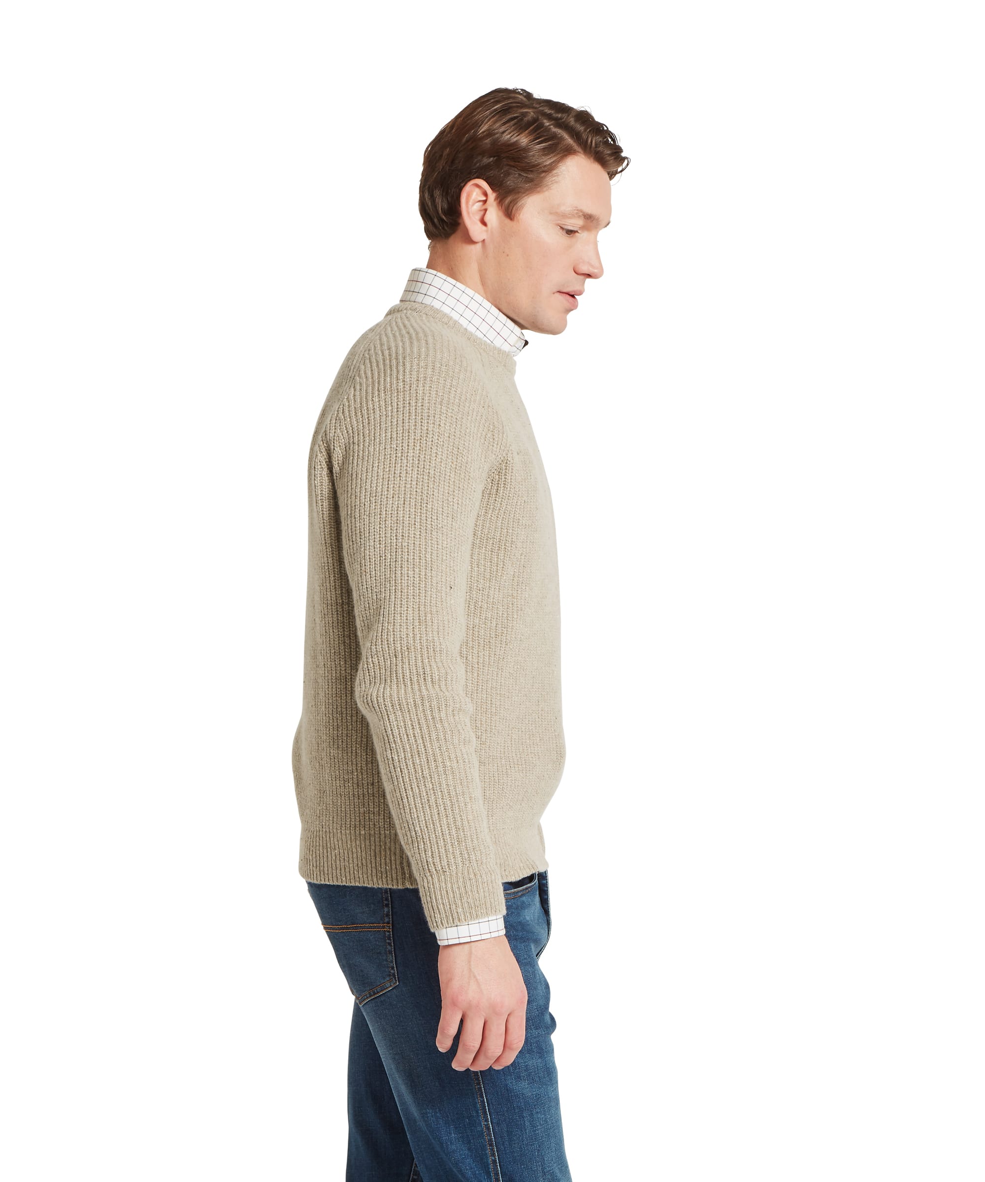 Schöffel Men's Balmaha Crew Neck Jumper in Beige - side profile view highlighting the chunky ribbed texture and raglan sleeve construction of the oatmeal lambswool crew neck, layered over a check shirt and jeans.