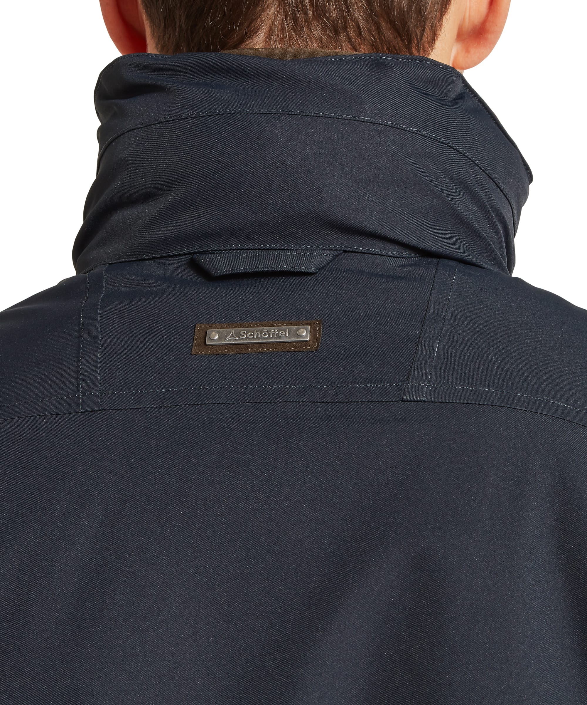 Schöffel Men's Barrow Country Coat in Navy - rear view showing the clean mid-length back panel, Schöffel badge tab at the collar, tailored seaming, and adjustable snap cuffs, worn with jeans.