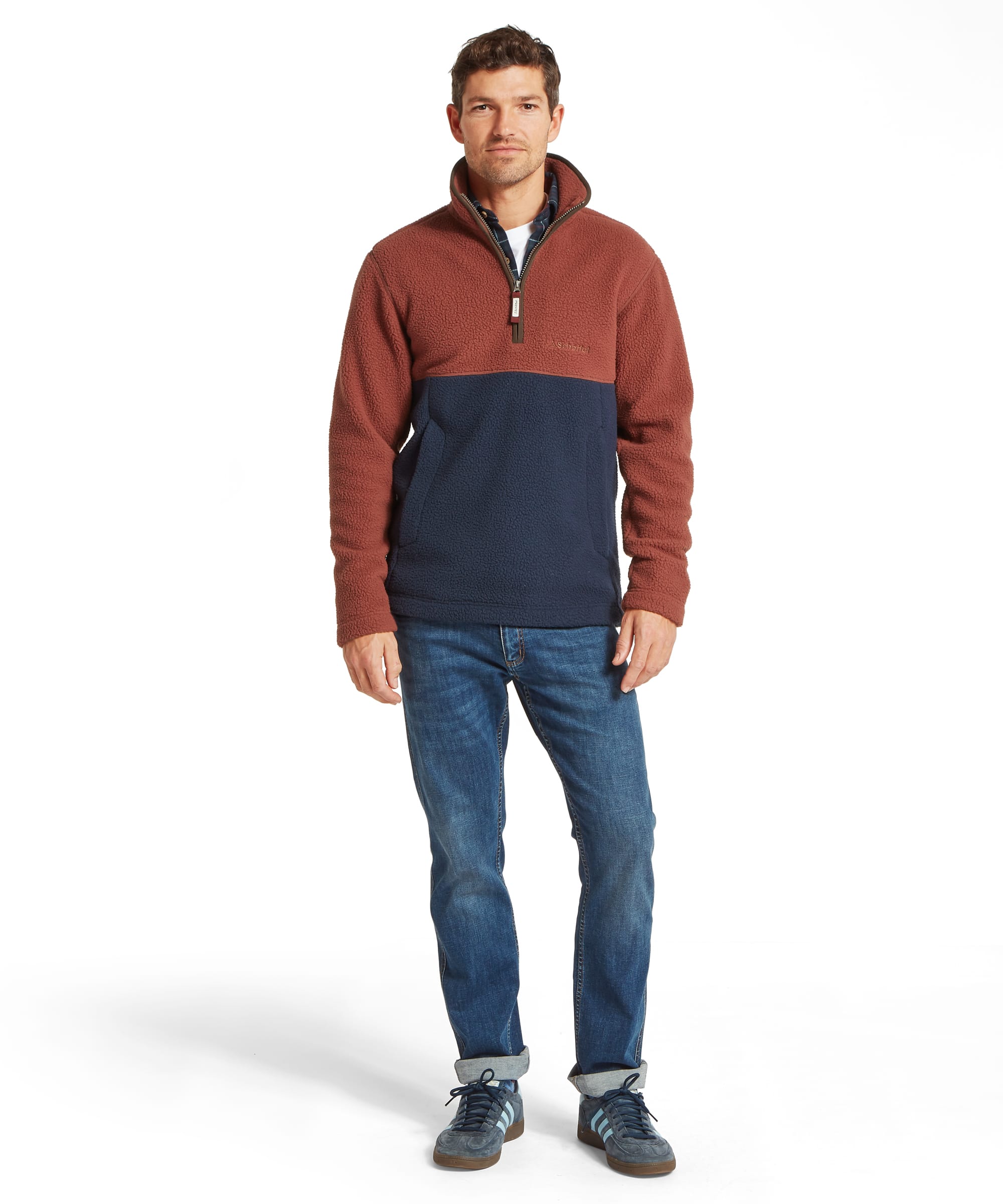 Schöffel Men's Berkeley Retro Fleece in Brown - full-length front view of the colour-block rust and navy sherpa quarter-zip fleece layered over a check shirt and white T-shirt, worn with blue jeans and Adidas Gazelle trainers.