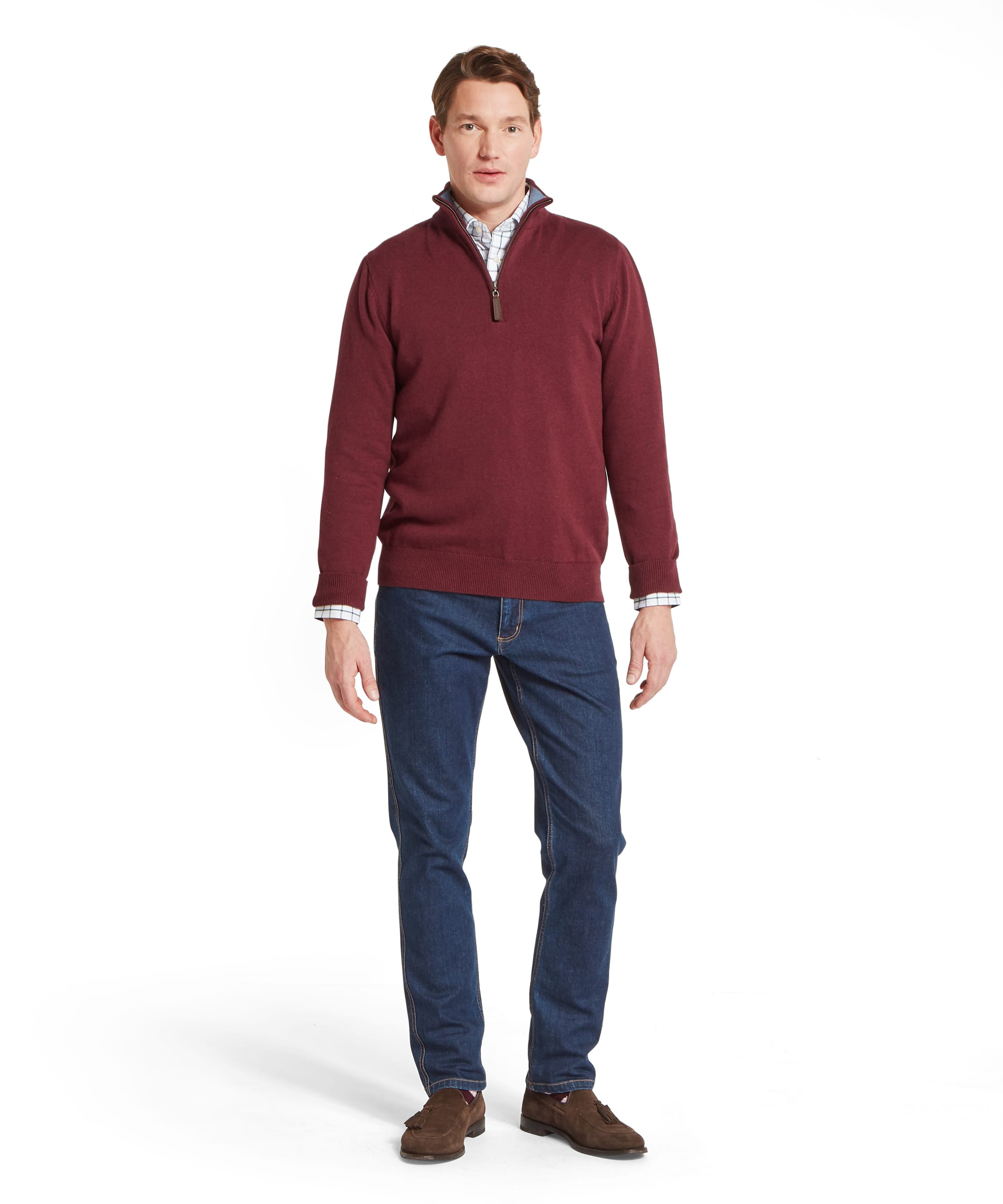 Schöffel Men's Calton Cotton Cashmere Quarter Zip Jumper in Red - three-quarter front view of a rich burgundy cotton-cashmere quarter-zip jumper with a funnel neck and leather zip pull, layered over a check shirt with blue jeans.