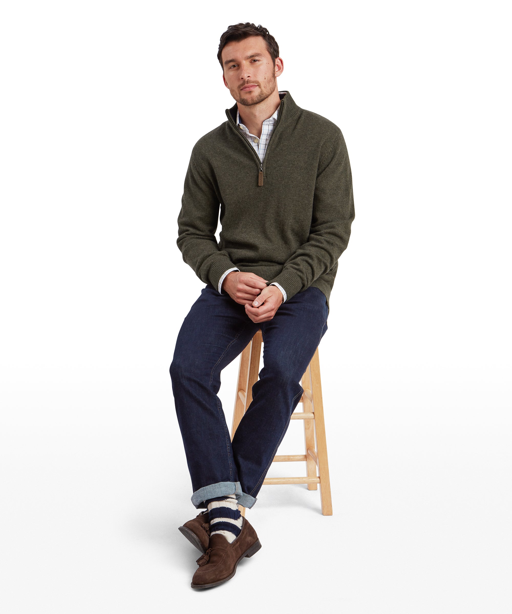 Man wearing Schöffel Calton cotton cashmere quarter-zip jumper in green, seated lifestyle shot