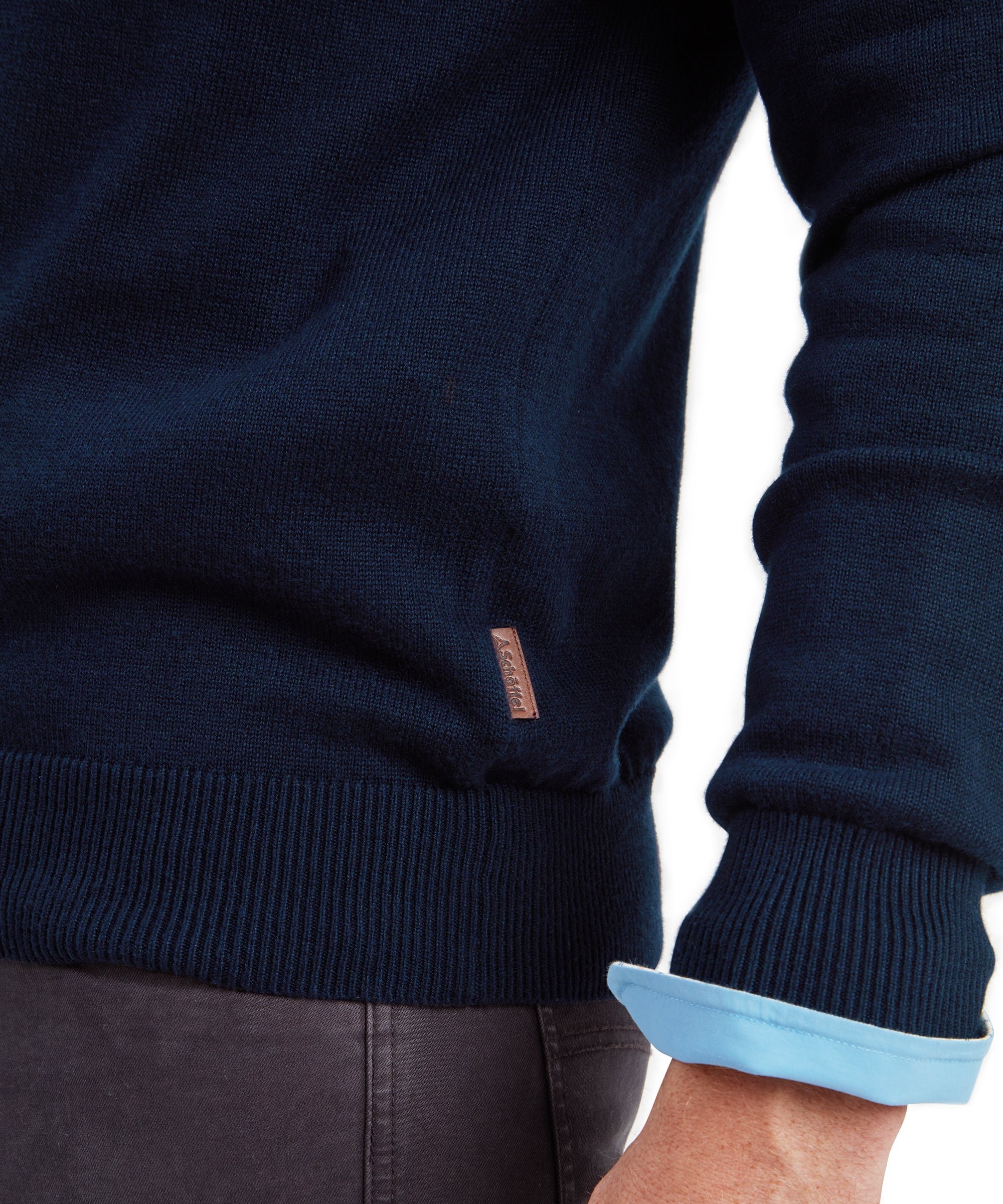 Schöffel men's Calton cotton cashmere jumper in navy, close-up of ribbed hem and leather brand patch