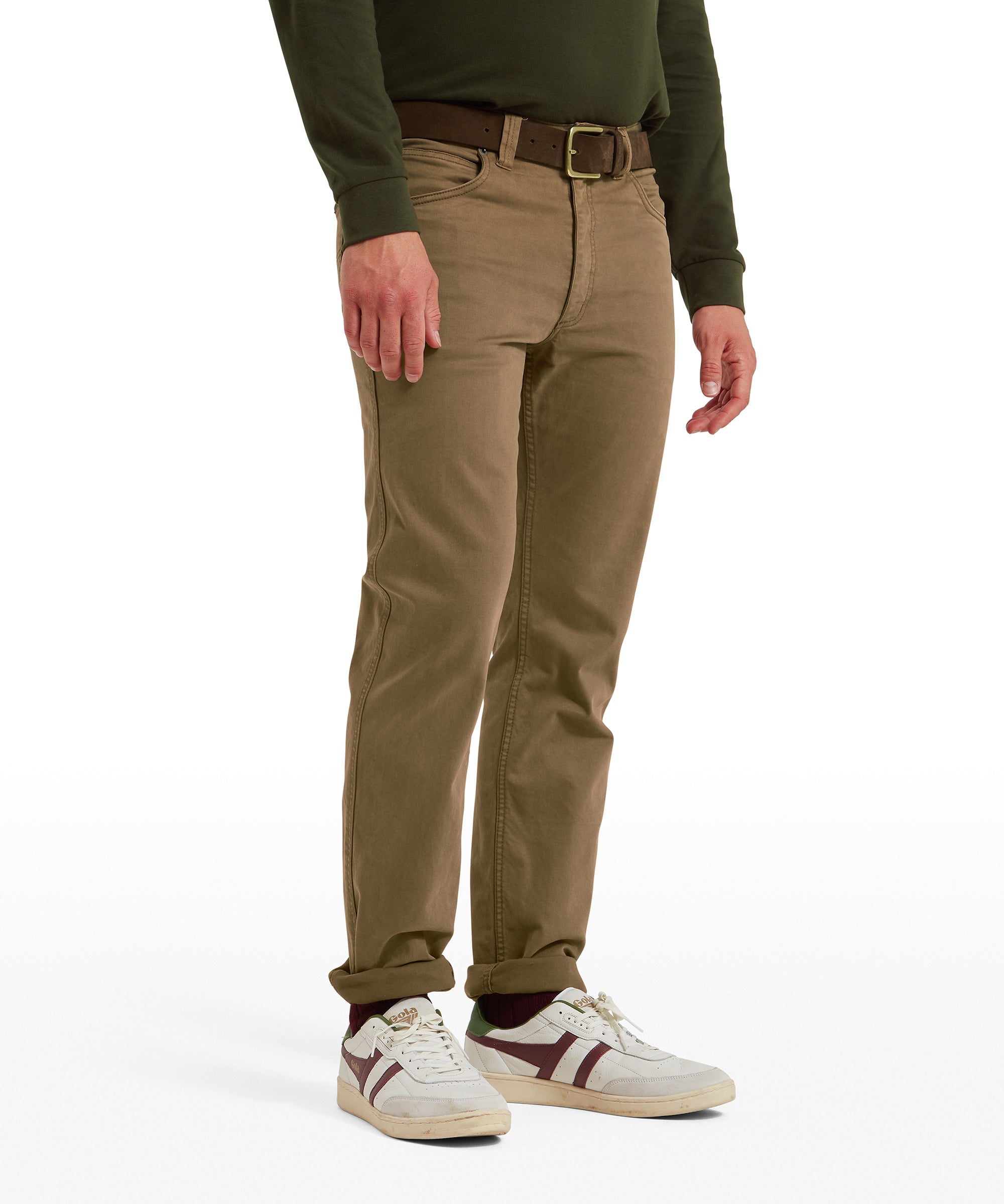 Person wearing brown jeans and a green shirt against a white background