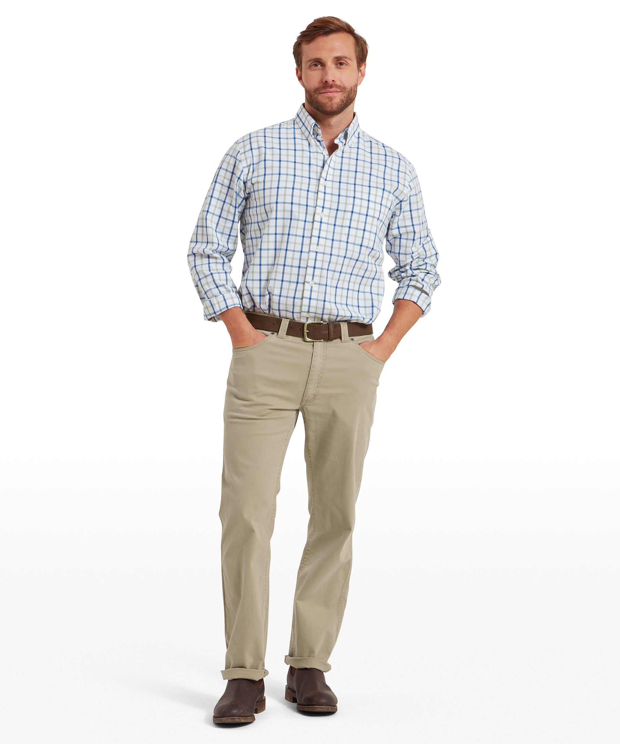 Man wearing a blue and white check shirt tucked into camel-coloured jeans, styled with a brown belt and dark brown leather shoes. Jeans are worn full length; hands are in pockets. Outfit presented in a standing pose on a transparent background.