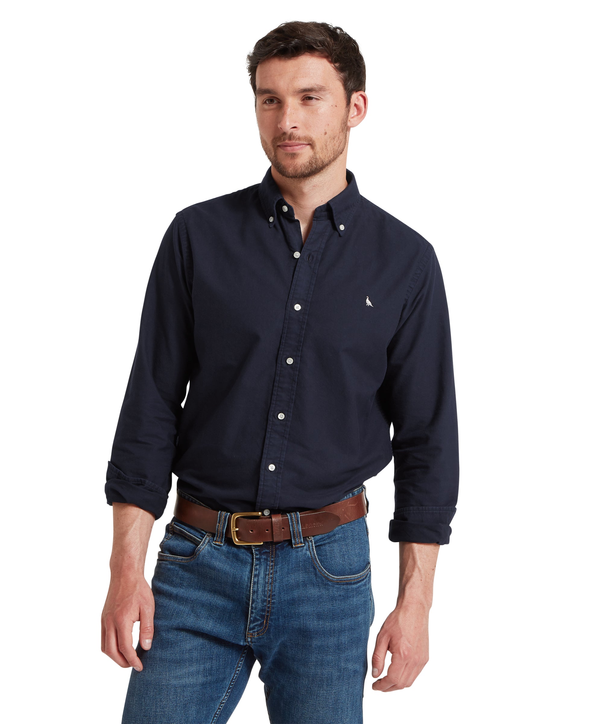 Man wearing a navy button-up shirt and blue jeans on a white background