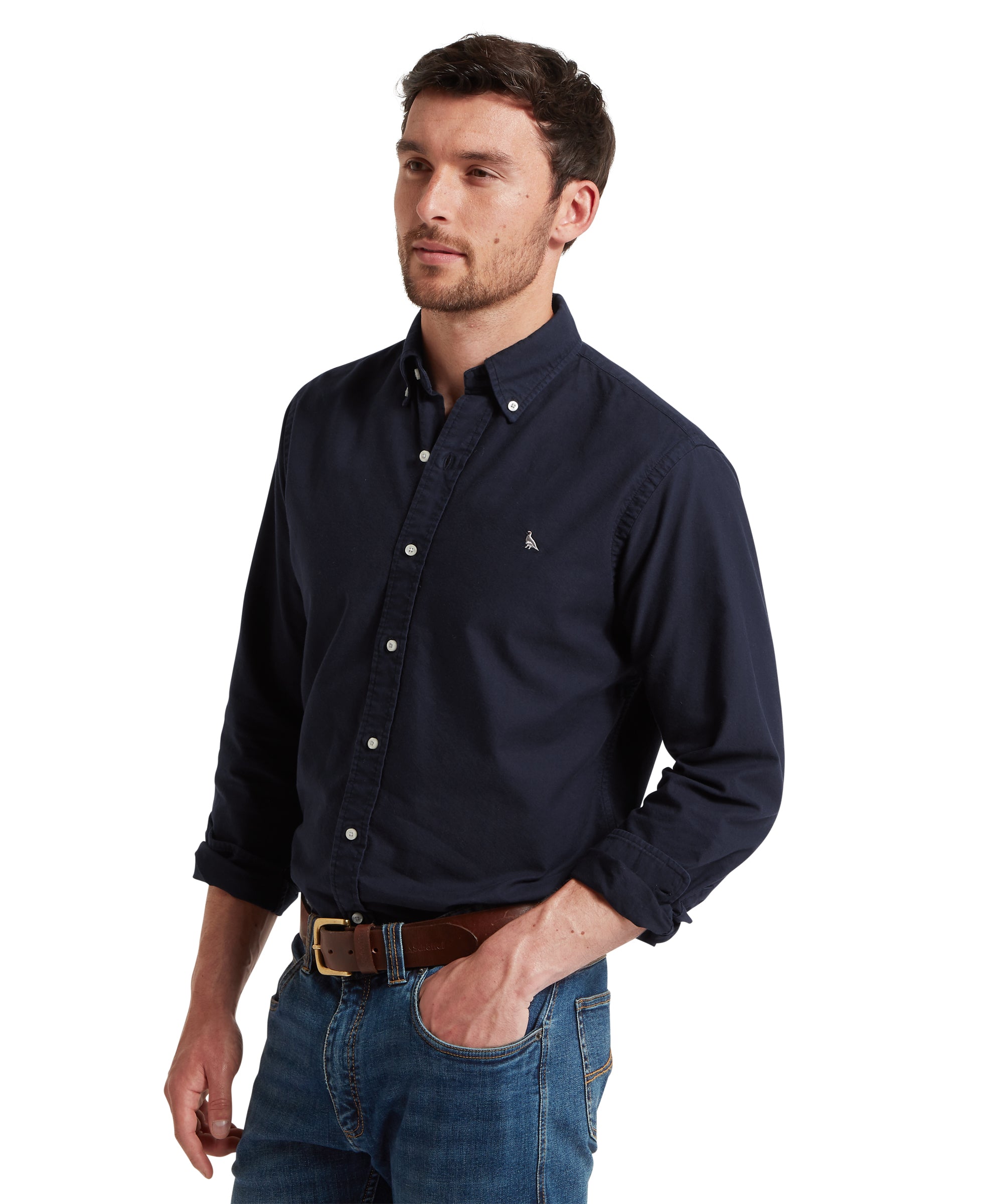 Man wearing a navy button-up shirt and jeans on a white background