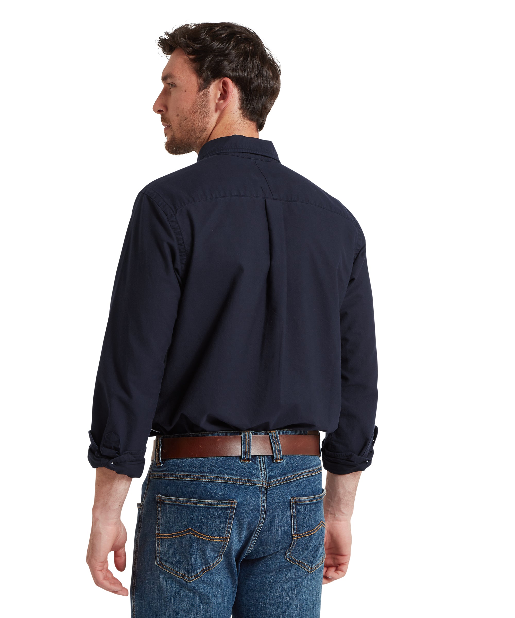 Man wearing a navy long-sleeve shirt and blue jeans on a white background
