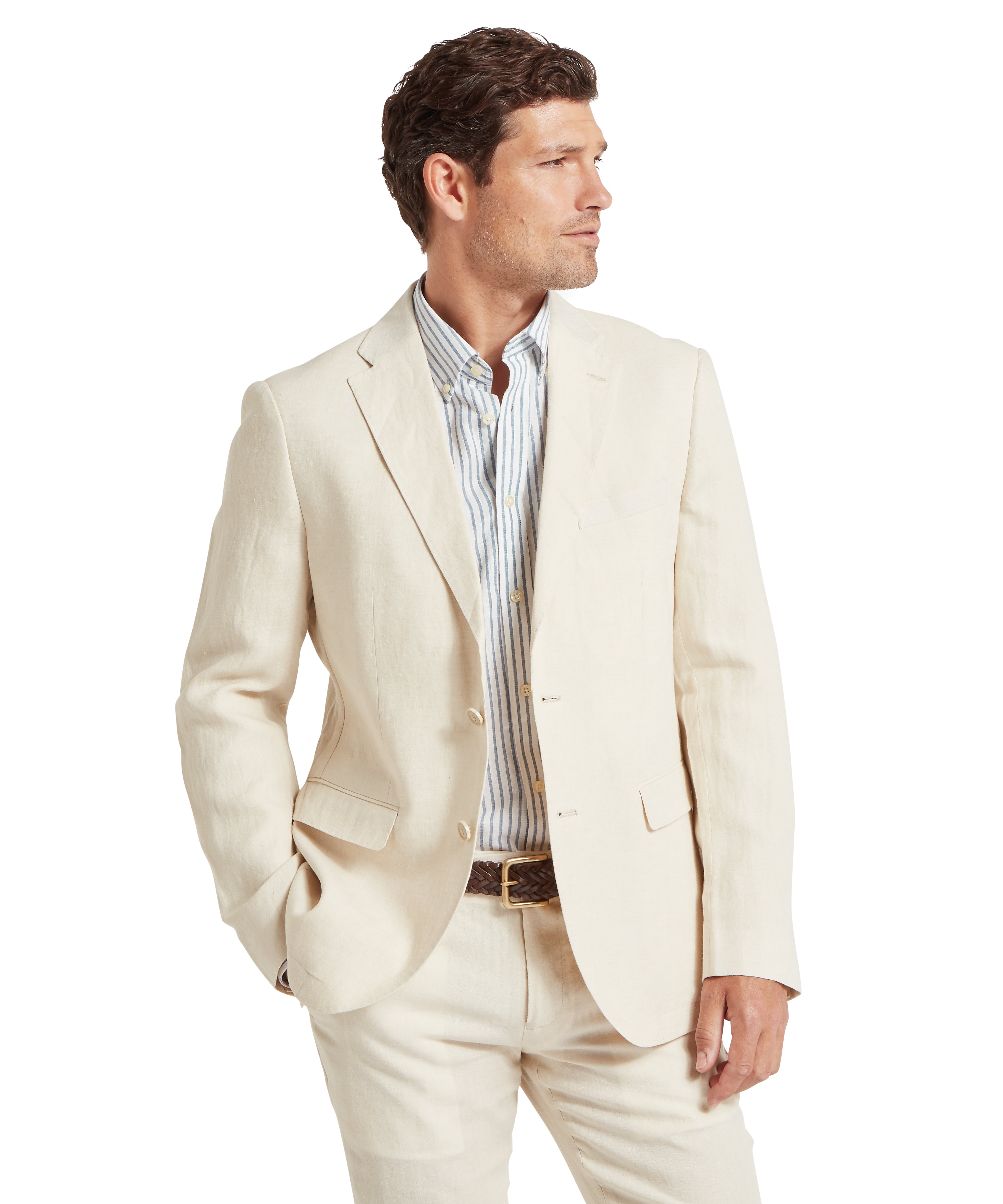 Man  wearing a cream suit consisting of a tailored blazer and matching trousers. The blazer features a notched lapel, two buttons, and flap pockets. Underneath is a light dress shirt with vertical blue and white stripes. A brown belt is visible at the waist. The outfit is formal and stylish, suitable for business or semi-formal occasions