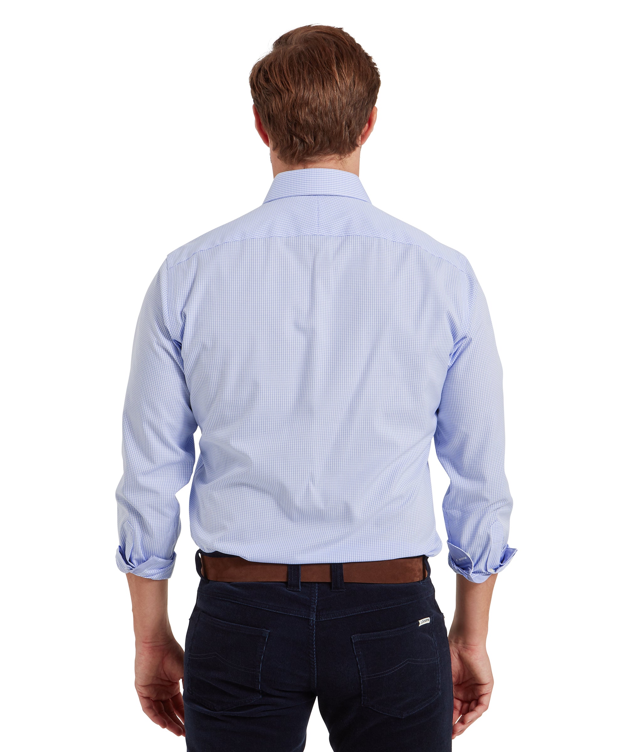 Man wearing a light blue, long-sleeved, button-down shirt with a subtle check pattern, viewed from the back. The sleeves are rolled up to the forearms, and the shirt is tucked into dark blue jeans secured with a brown belt. His hair is neatly styled. The outfit presents a casual yet polished look, suitable for everyday or smart-casual occasions.