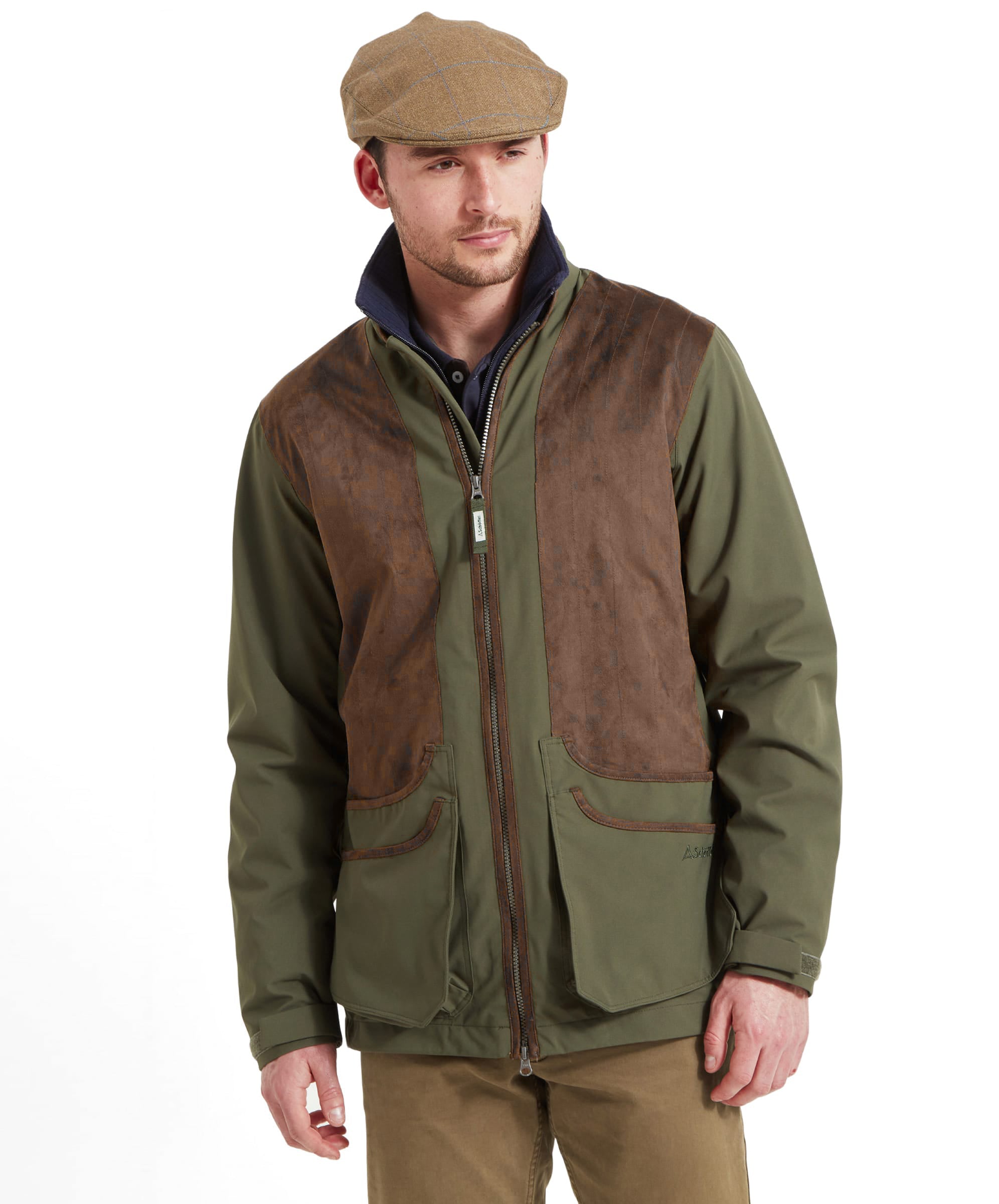 Man wearing the Schöffel Grimsthorpe Clay Shooting Jacket in Green with a tweed flat cap, front view styled with chino trousers for the clay ground.