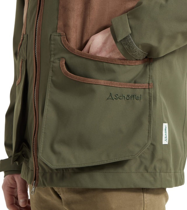Schöffel Grimsthorpe men's clay shooting jacket in green, close-up of front bellows pocket with contrast leather-effect trim, embroidered logo and full-length zip