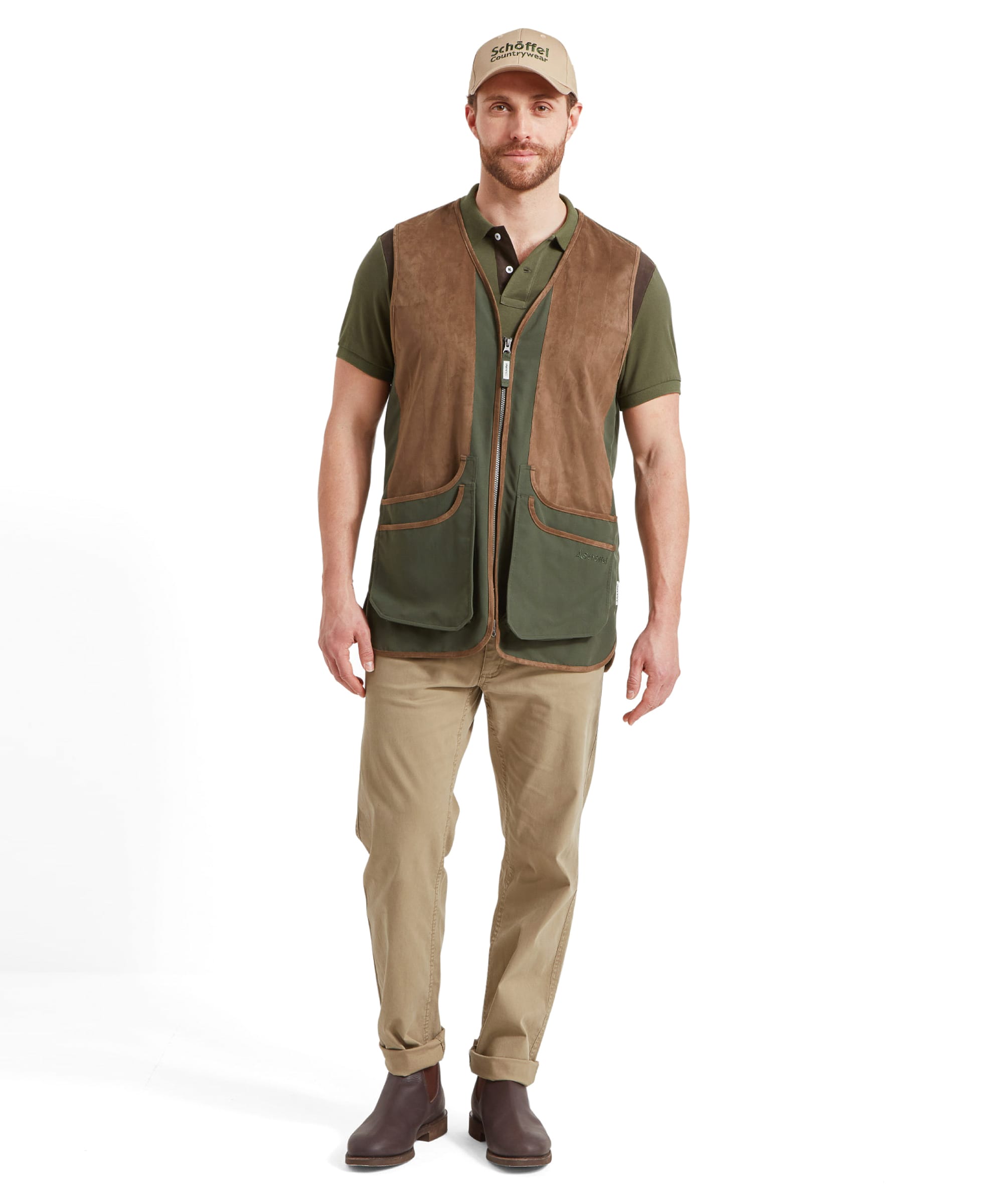 Schöffel Men's Grimsthorpe Clay Shooting Vest in Green — full-length front view styled with khaki chinos, polo shirt and brown Chelsea boots, worn with a Schöffel Countrywear cap