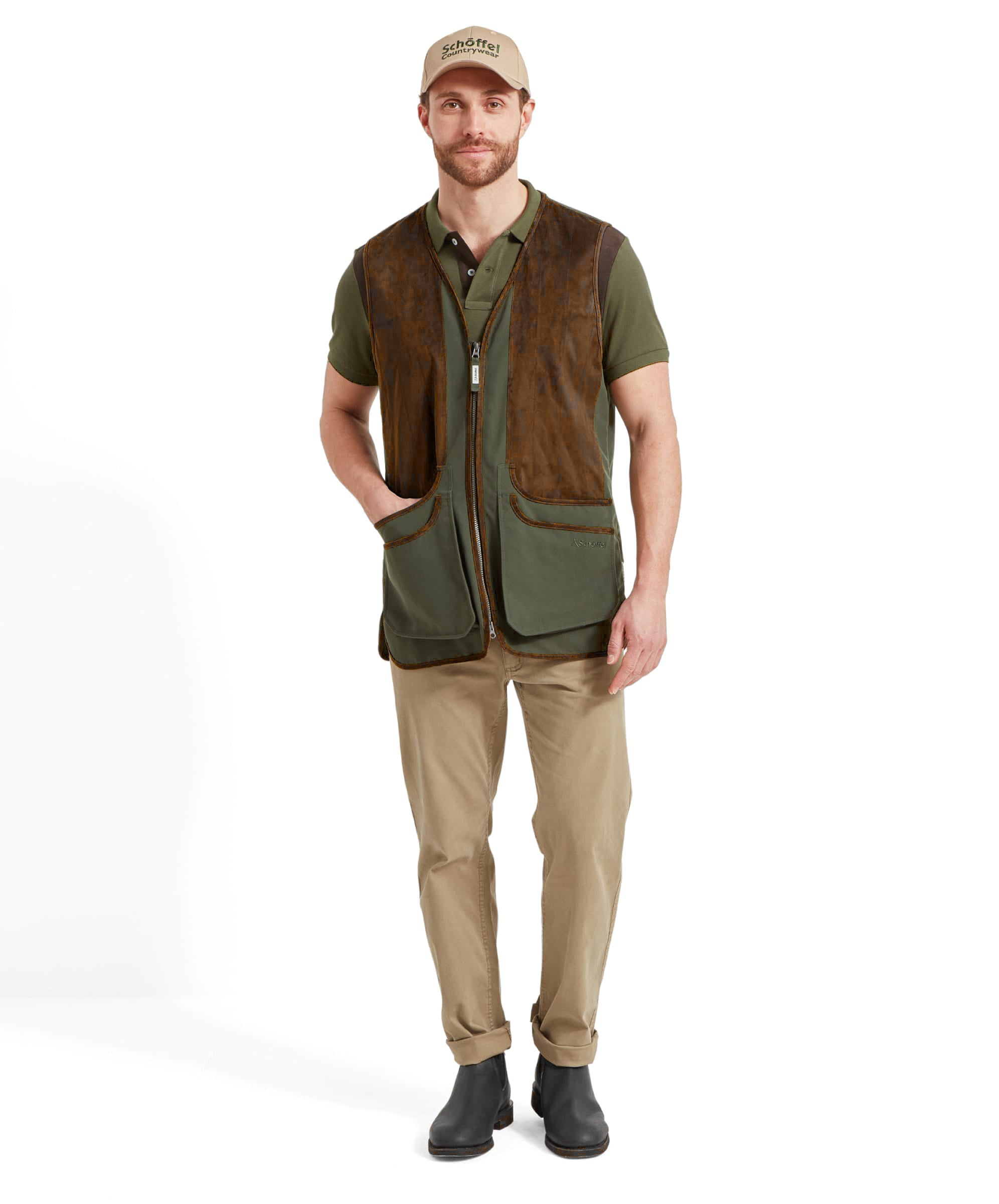 Man wearing the Schöffel Grimsthorpe Clay Shooting Vest in Green with a branded cap, full-length front view styled with chinos and Chelsea boots.