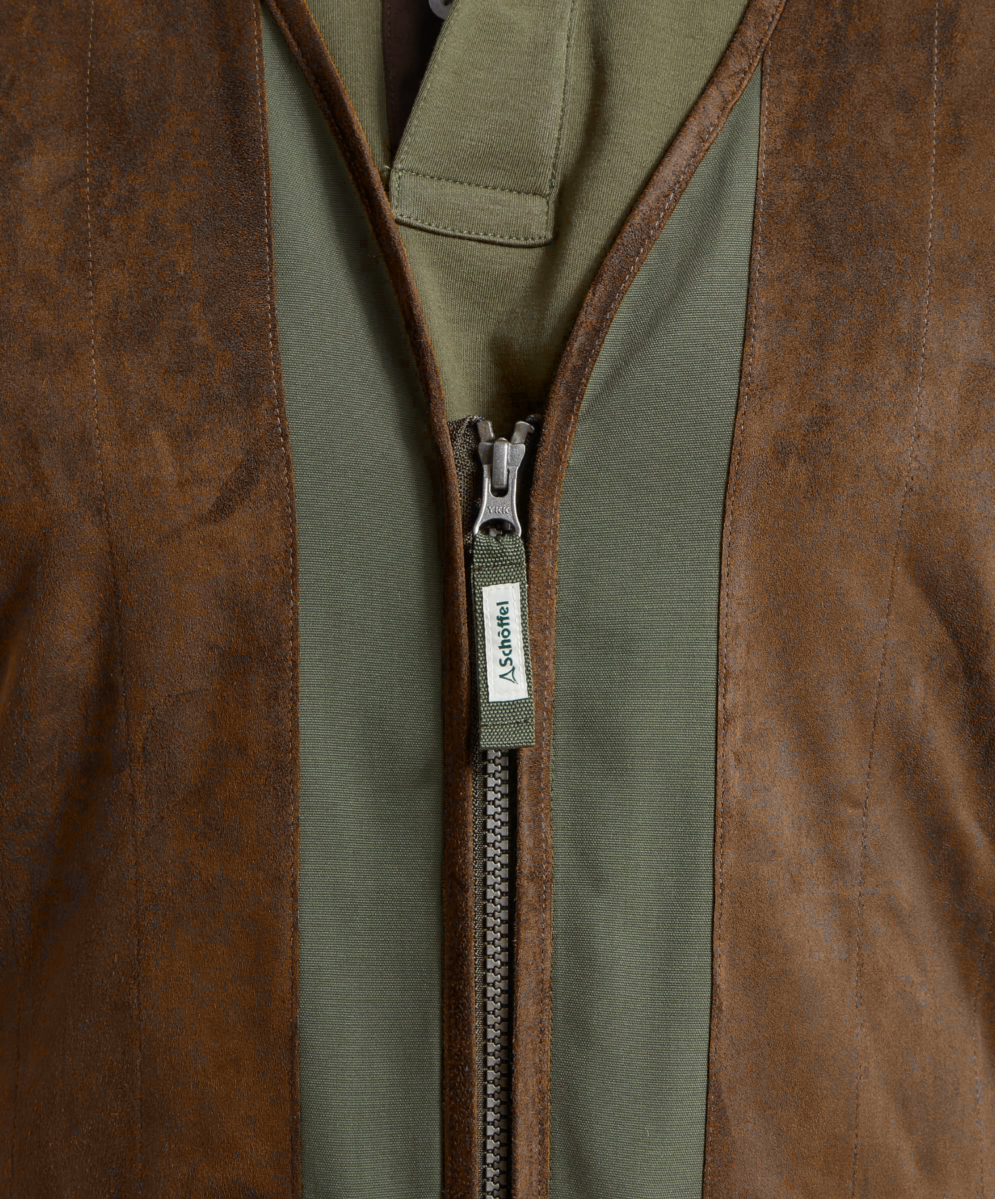 Close-up of the Schöffel Grimsthorpe Clay Shooting Vest in Green, showing the two-way zip and embroidered branded puller.