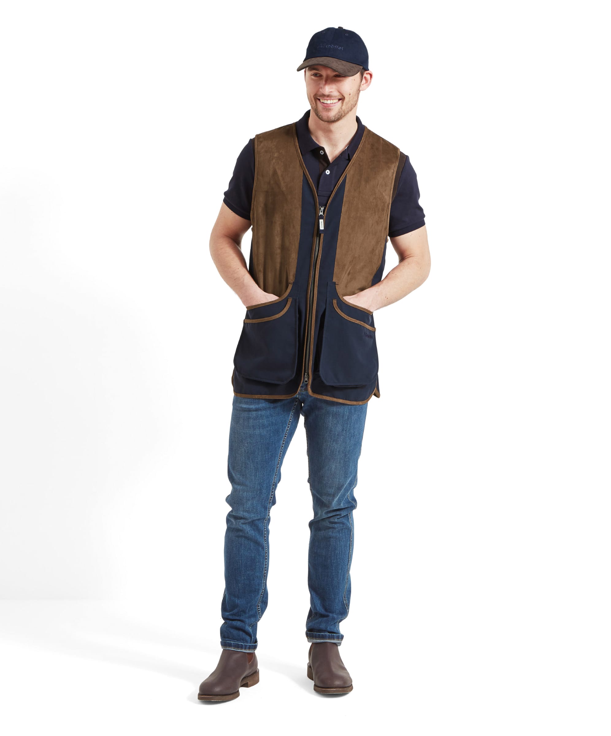 Schöffel Men's Grimsthorpe Clay Shooting Vest in Blue — full-length front view styled with dark jeans and brown Chelsea boots, worn with a Schöffel cap