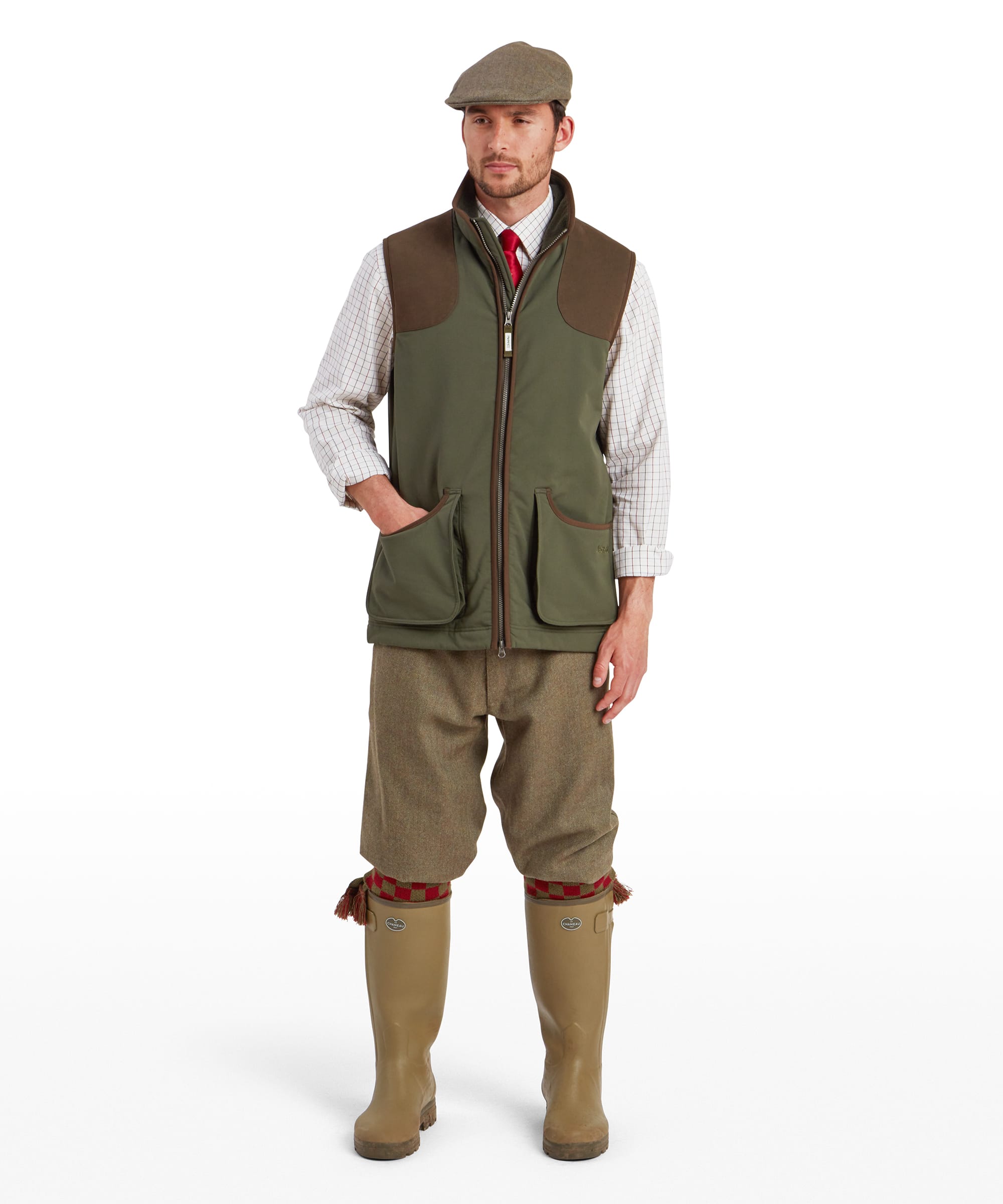 Schöffel Men's Gunby Gilet in Green — full-length front view styled with tweed plus-fours, check shirt, tie and rubber field boots, worn with a tweed flat cap