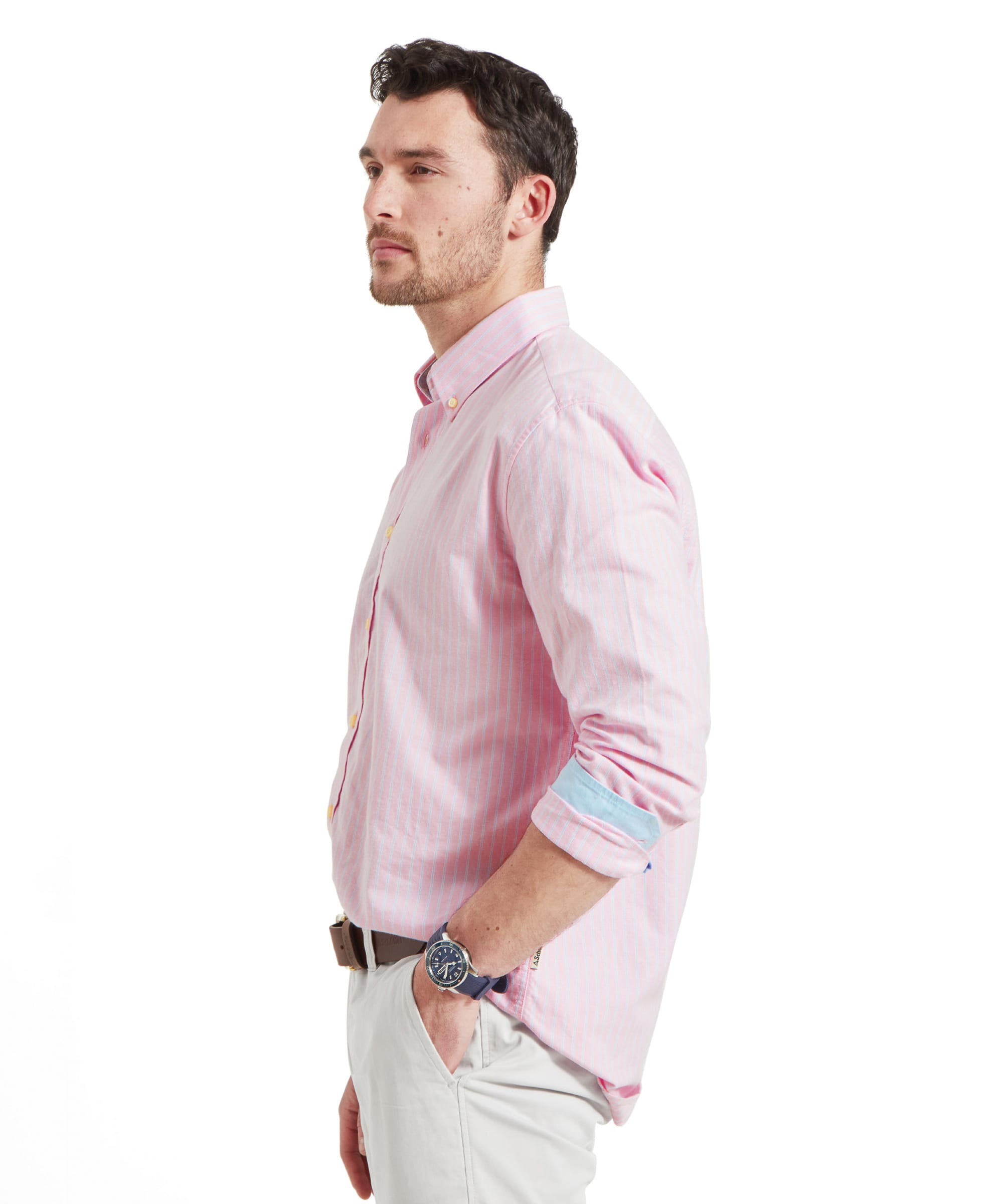 Side view of the Schöffel Holt Soft Oxford Tailored Shirt for Men in Pink Stripe highlighting the shirts length and the blue detail on the inside of the cuff as it's rolled up the mans forearm.