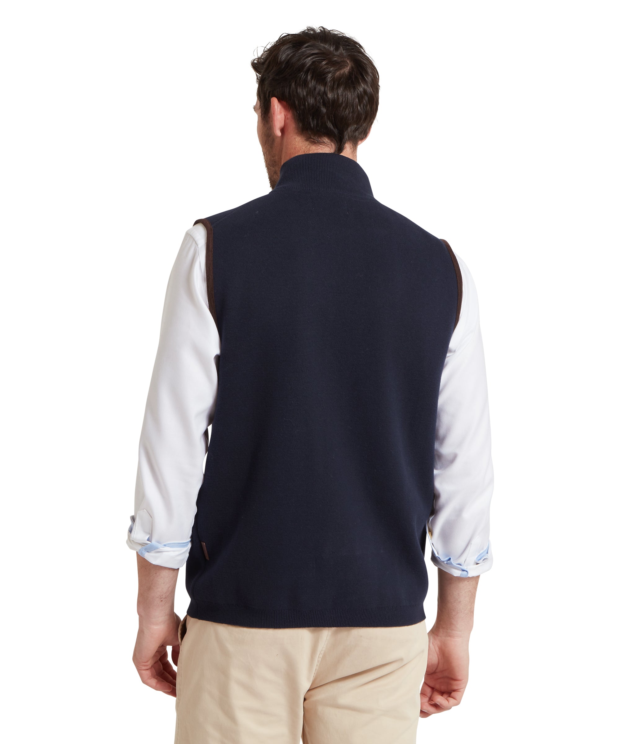 Man wearing a navy gilet over a white shirt on a white background