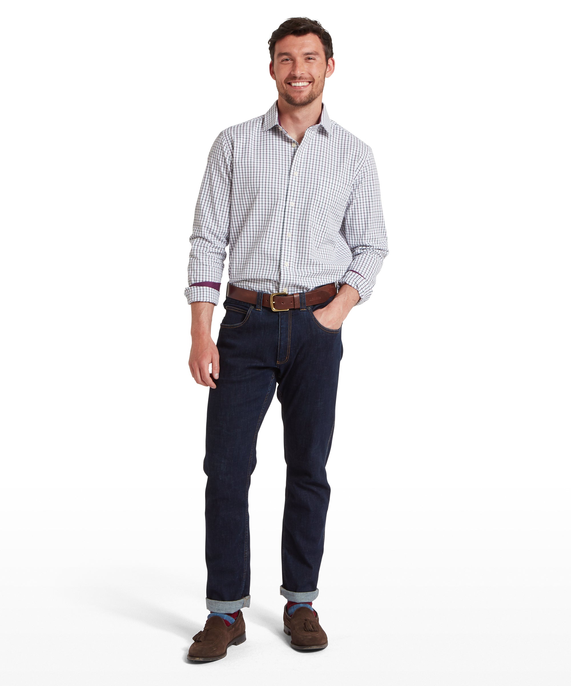 Man wearing a checkered shirt and dark jeans on a white background