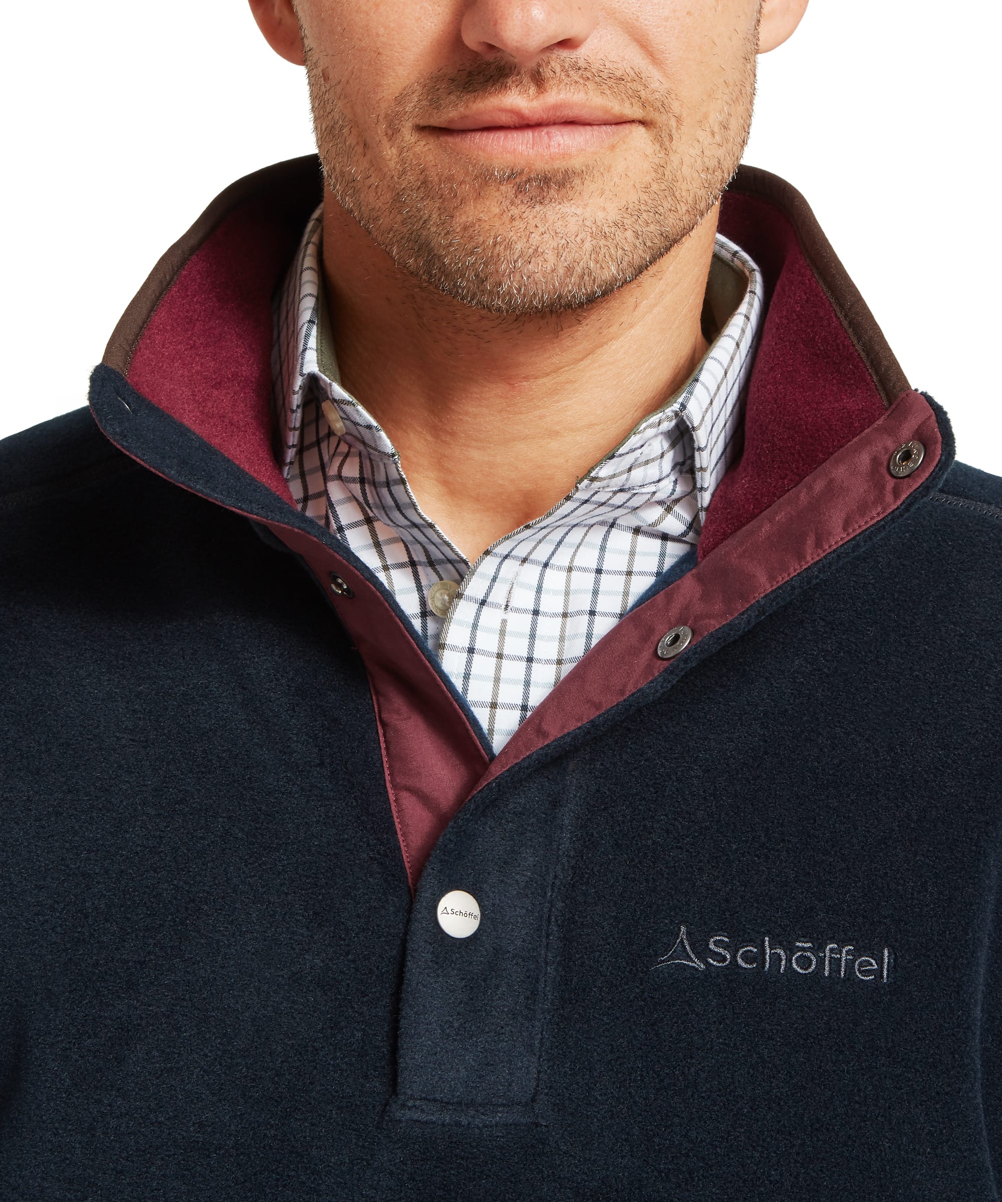 Close-up of Schoffel Mens Norton Fleece collar in navy showing snap-button placket fastening, contrast burgundy inner collar lining, Schoffel branded button and Schoffel chest logo embroidery, worn over a check shirt
