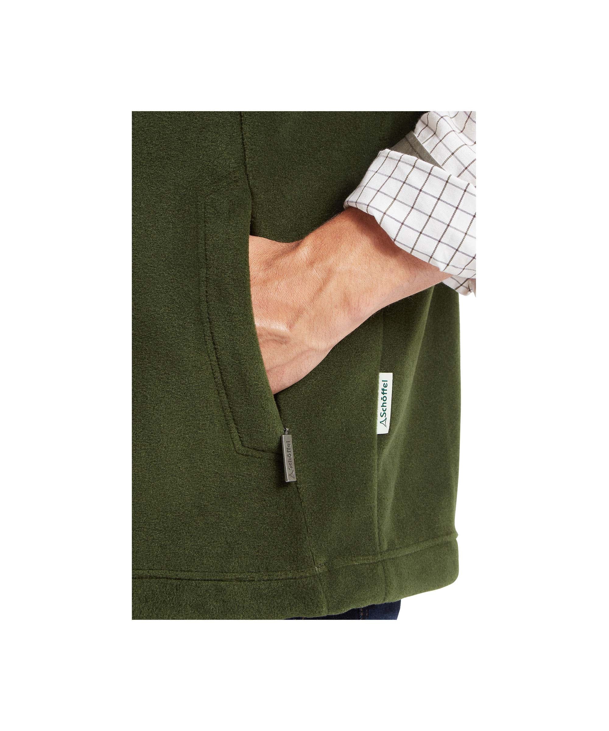 Schöffel Men's Oakham Fleece Gilet in Green on male model, close-up showing zipped side pocket and branded tab detail