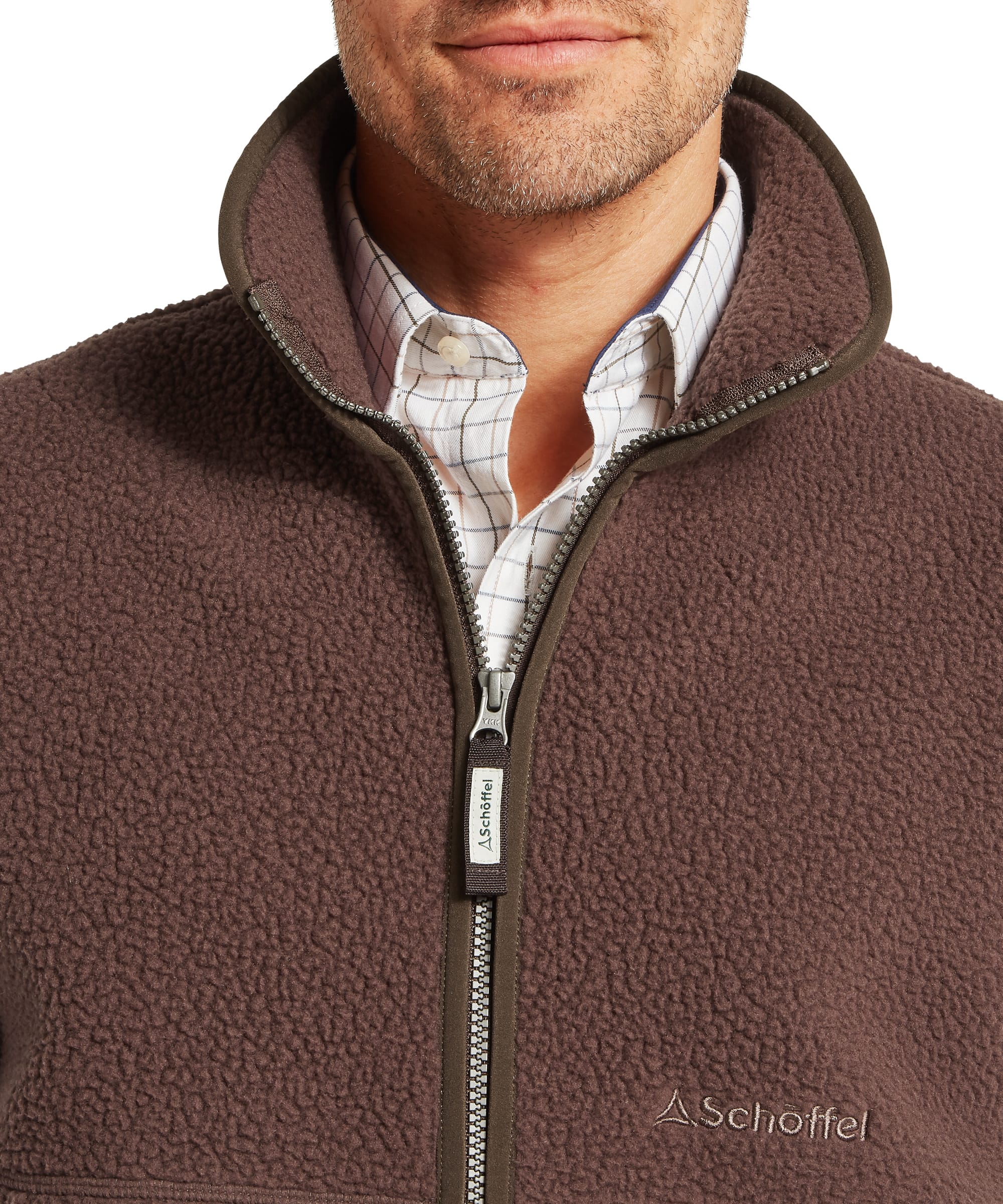 Close-up of Schoffel Mens Oakham Retro Fleece Gilet in dark brown showing full-length zip neck with Schoffel woven zip pull, contrast dark olive collar binding and Schoffel chest logo on deep-pile sherpa fleece